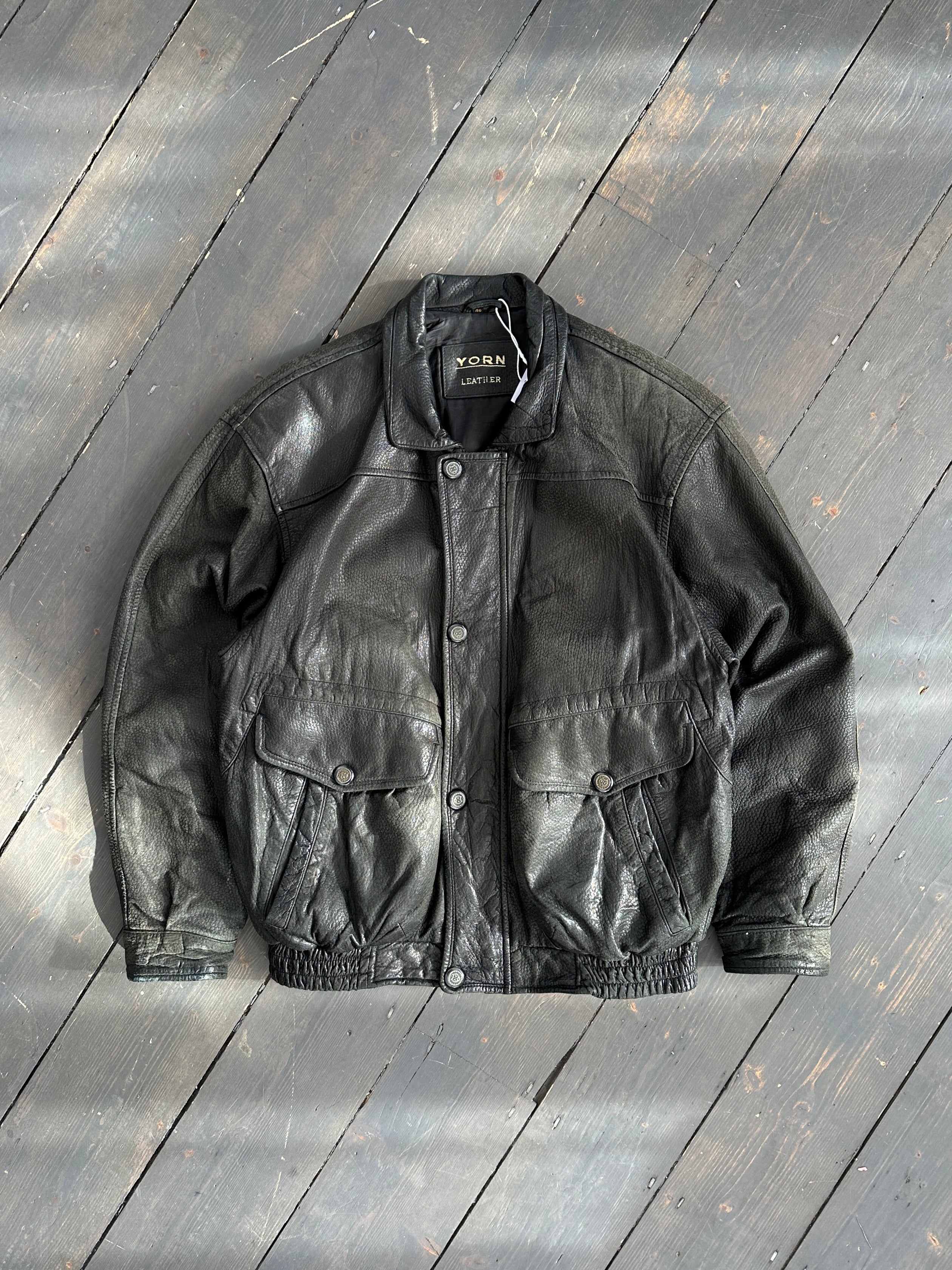 Vintage textured leather bomber jacket in M/L size, featuring classic style and detailed craftsmanship, displayed on a hanger.