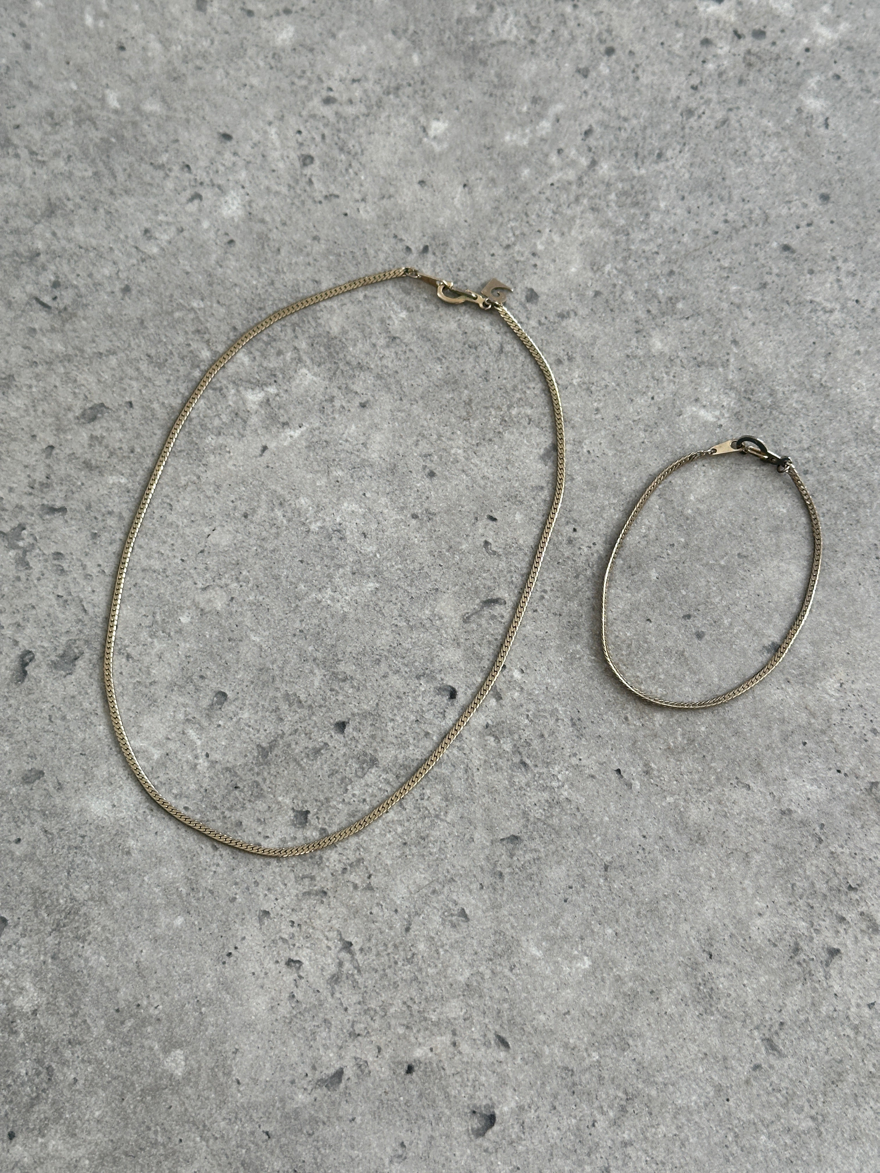 Gold plated Pierre Cardin necklace and bracelet chain set with sleek, matching links, styled for elegant wear.
