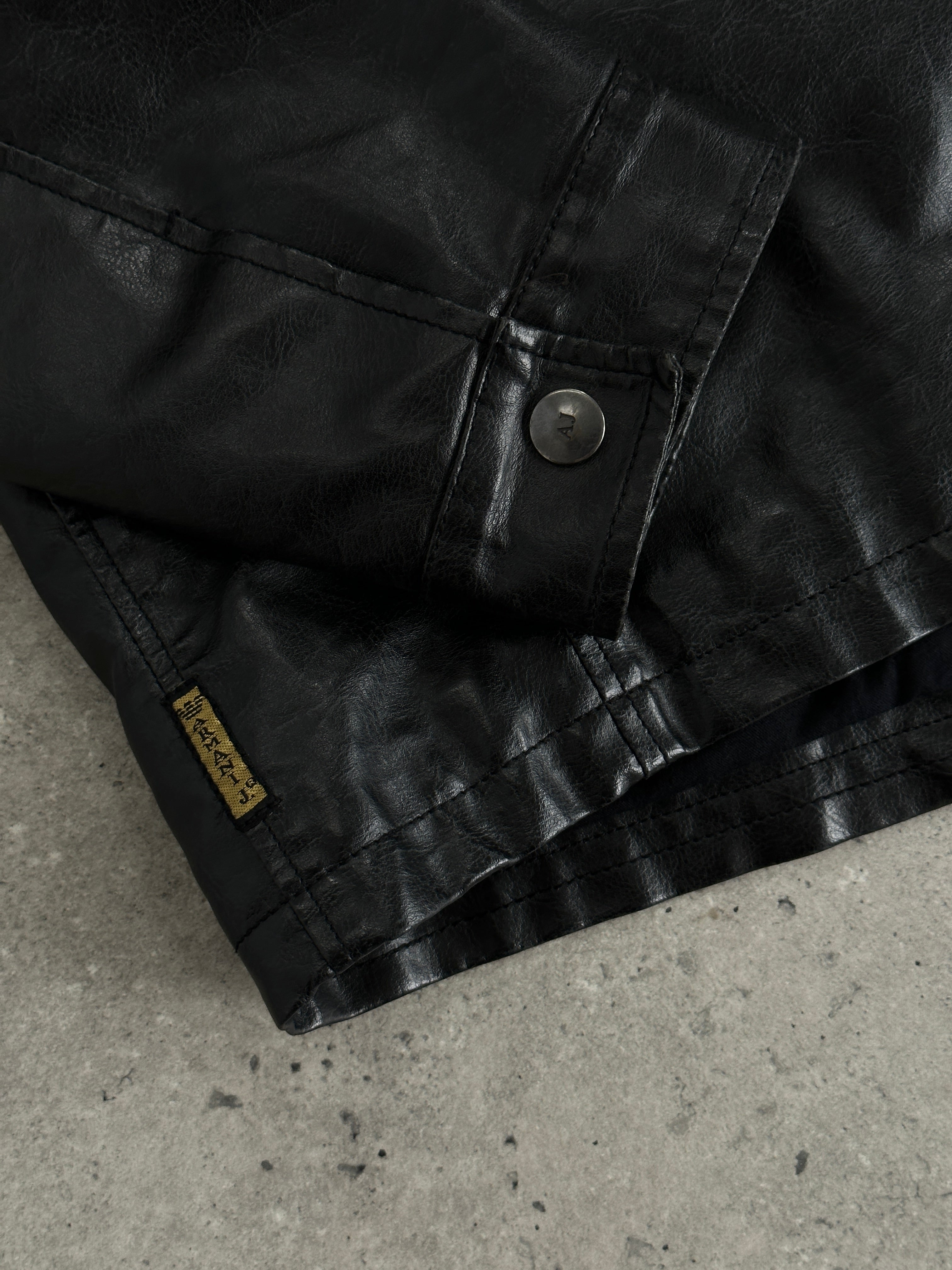 Armani Jeans faux leather biker jacket in size M, featuring classic lapels and zip details, stylishly displayed on a hanger.