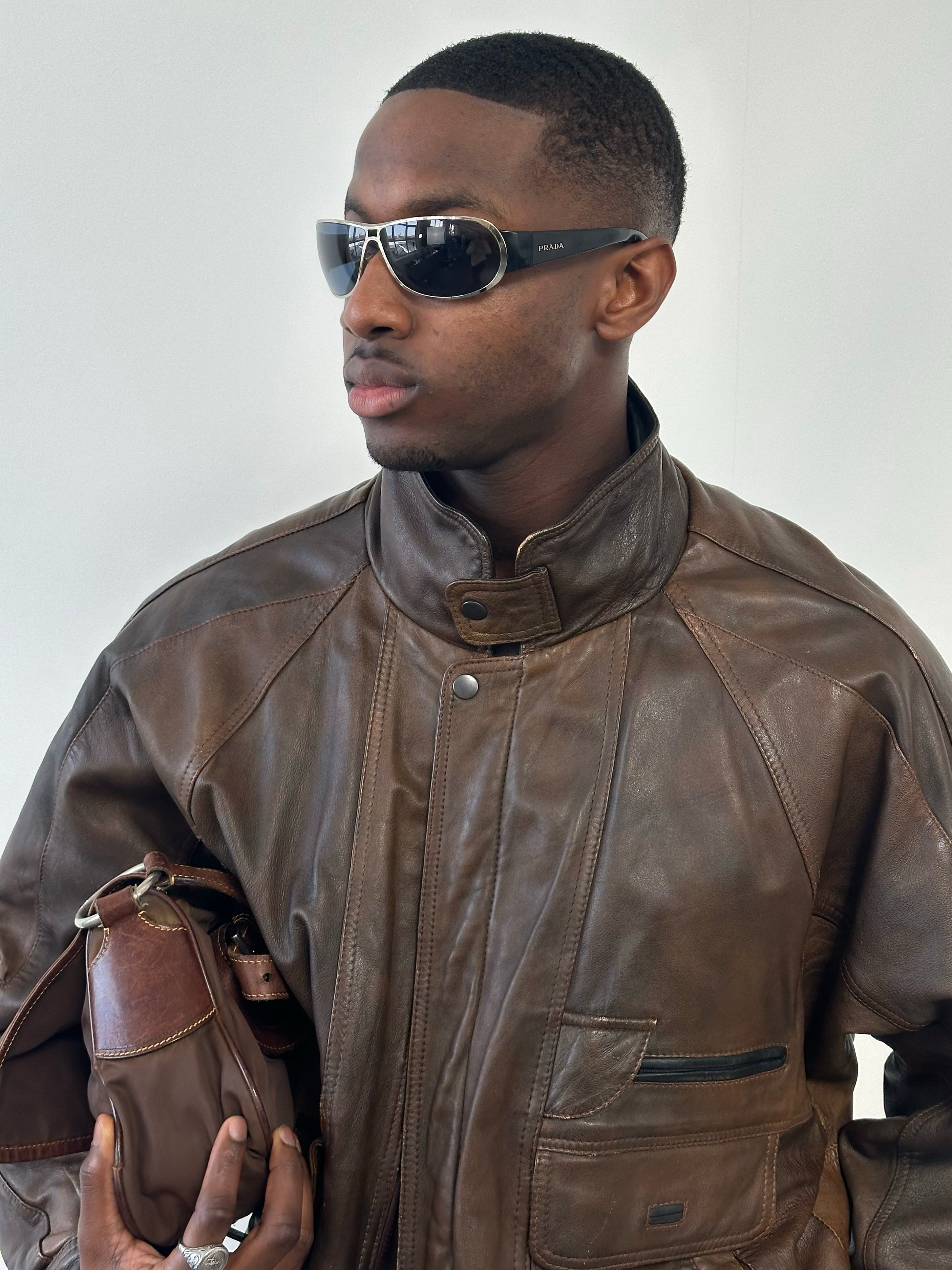 Vintage 1990s leather bomber jacket with high neck, size XL, featuring classic distressed leather and vintage style.
