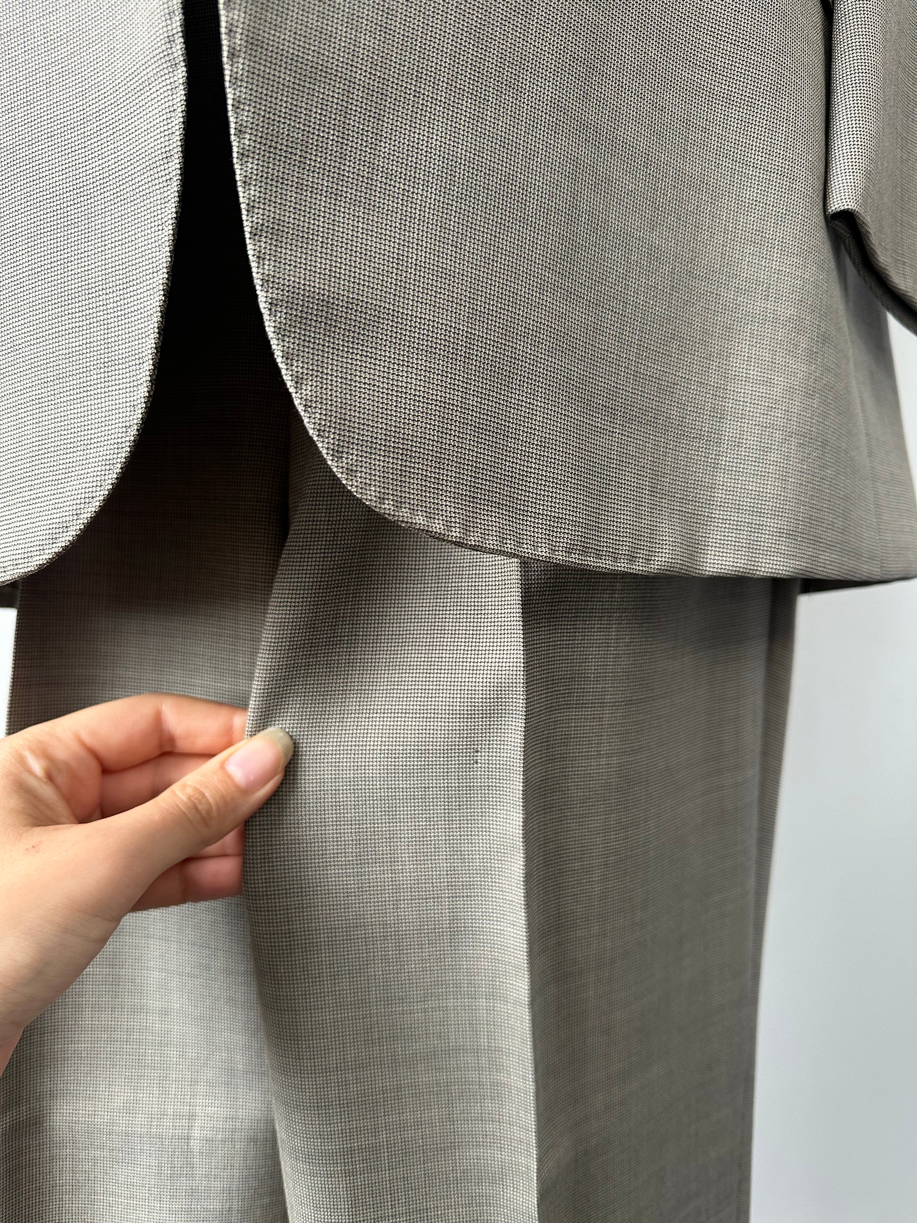 Burberry 1990s pure wool single-breasted suit in classic design, displayed on a hanger with visible fabric texture and tailored fit.