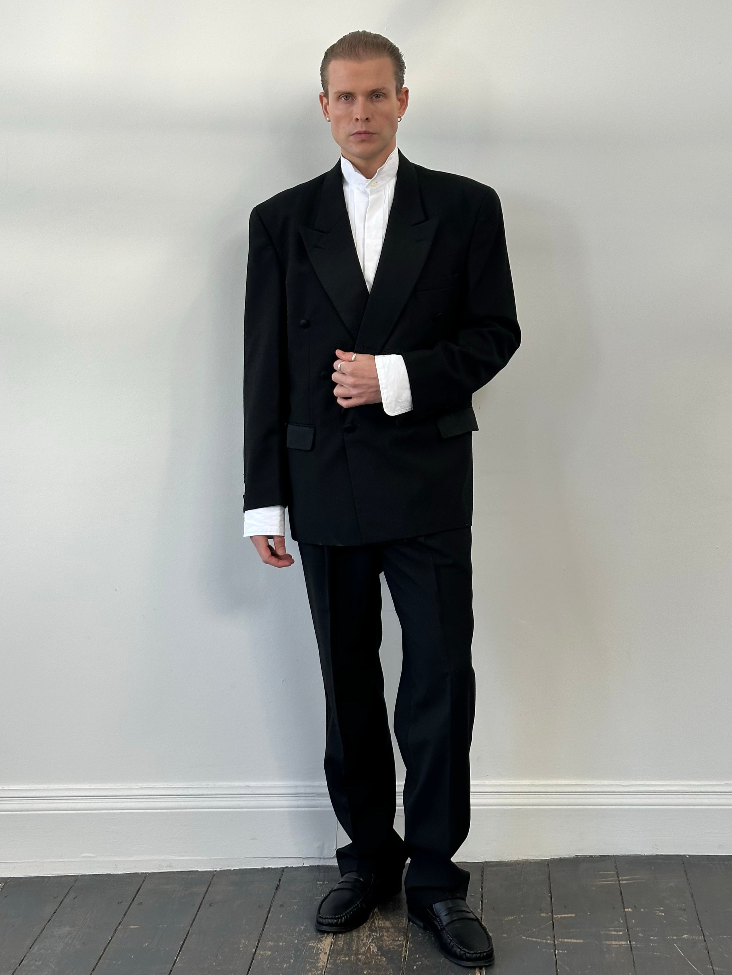 Vintage 1990s wool double-breasted tuxedo suit in size 44R/W32, featuring classic lapels and tailored fit, on a hanger.