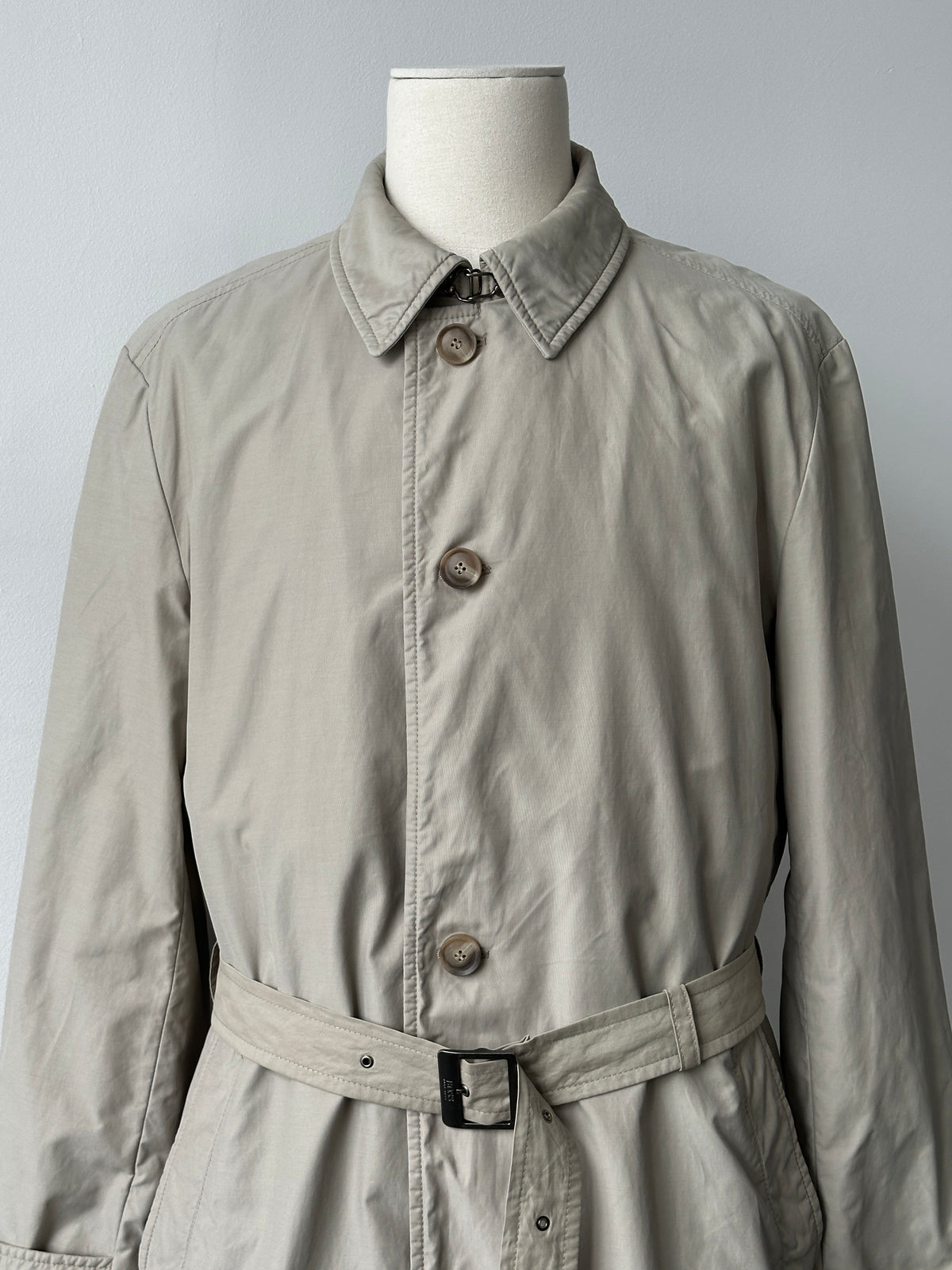 Hugo Boss 2000s high neck belted trench coat in beige, front view showing belt, high collar, and classic trench design.