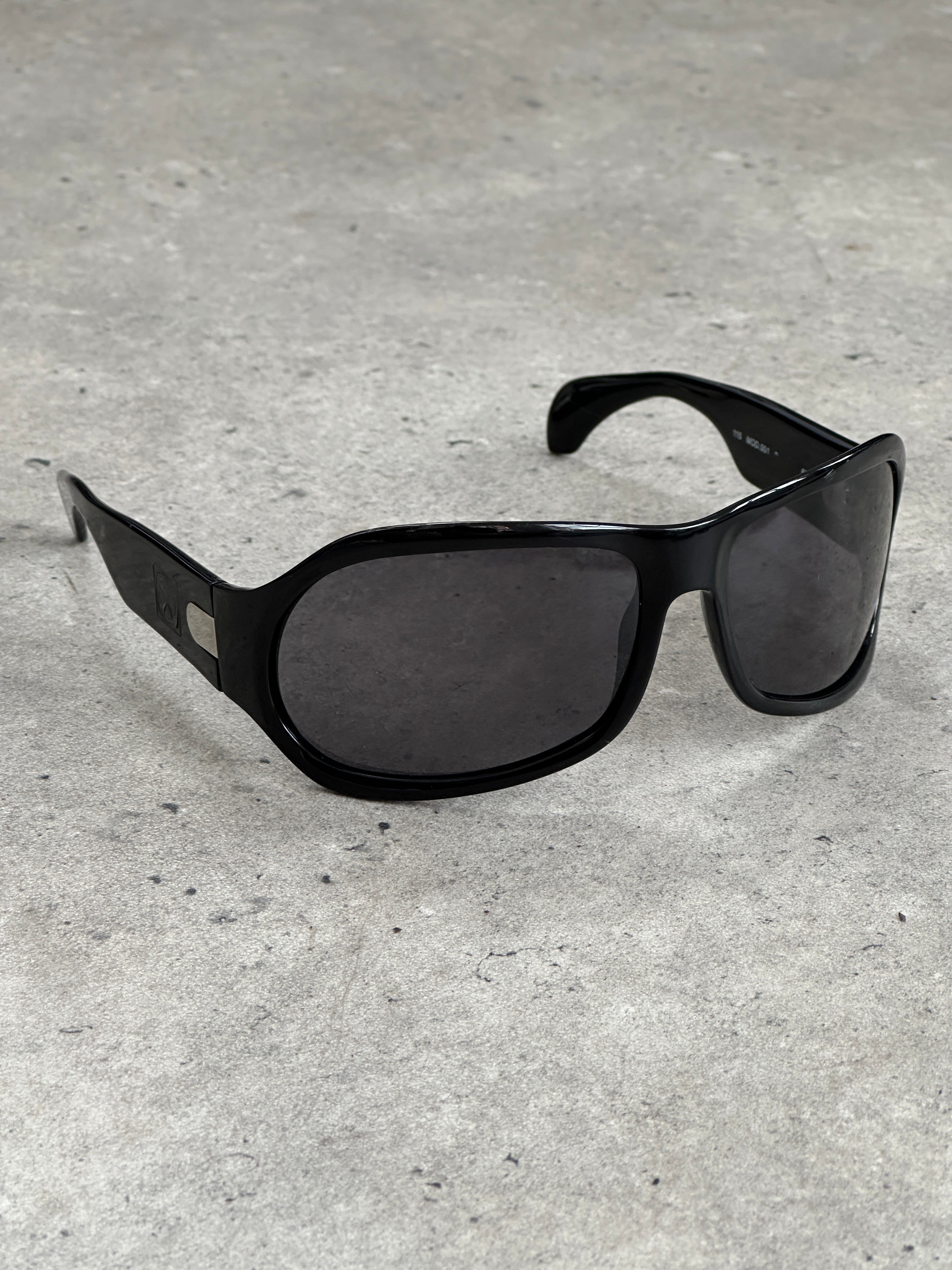 Vintage 2000s oversized shield sunglasses with dark tinted lenses and thick black frames, vintage brand style.