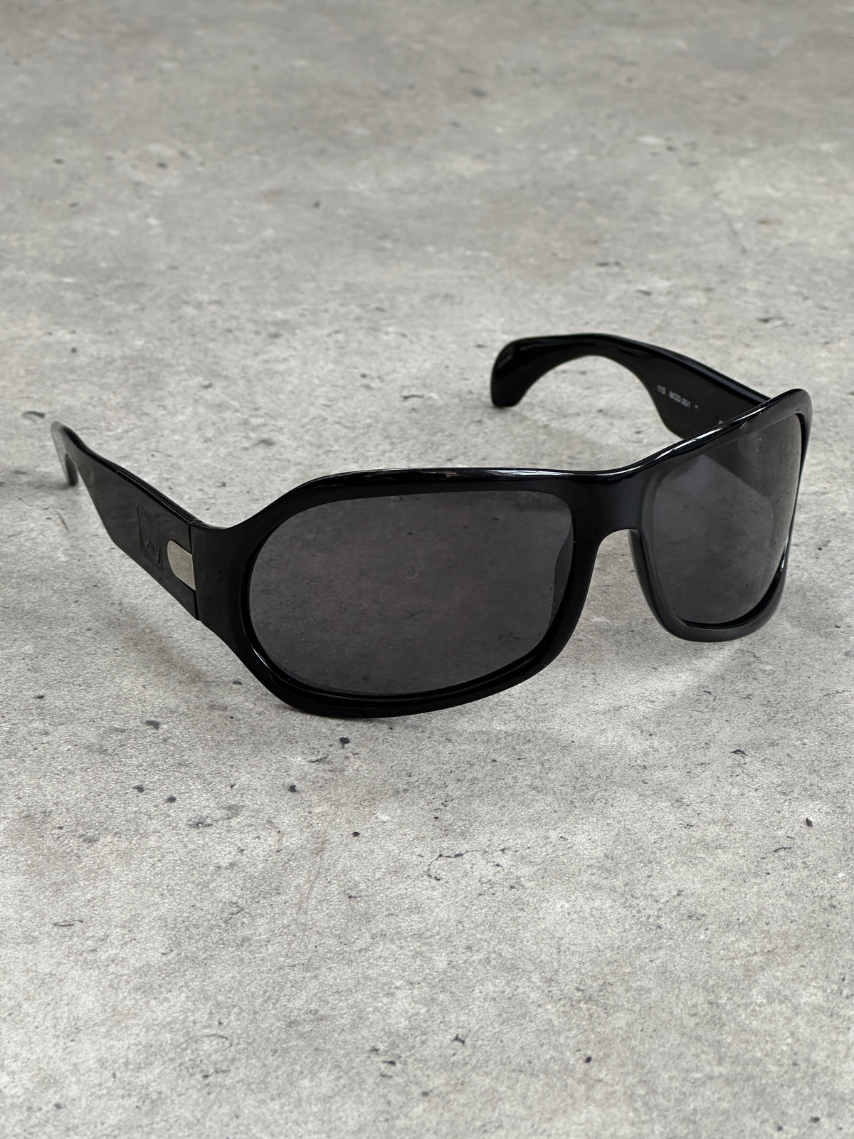 Vintage 2000s oversized shield sunglasses with dark tinted lenses and thick black frames, vintage brand style.