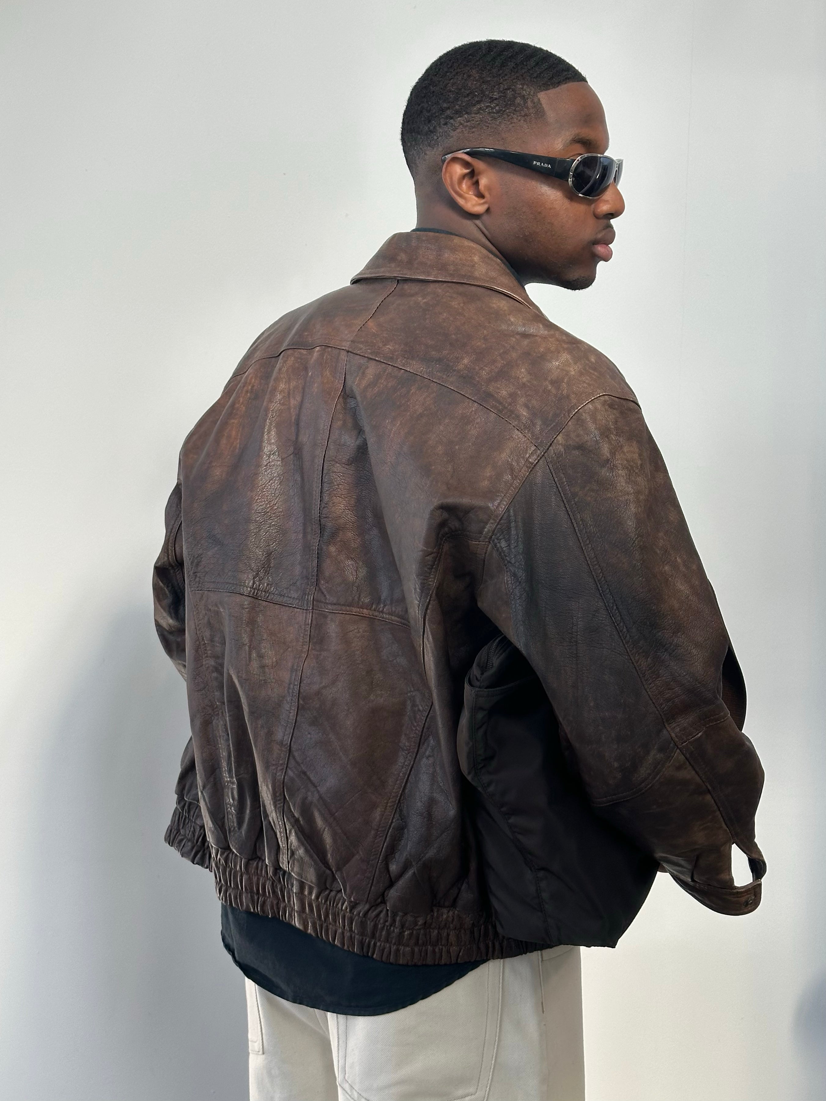 Vintage 1990s distressed leather bomber jacket, size M, showcasing rugged texture and classic style.