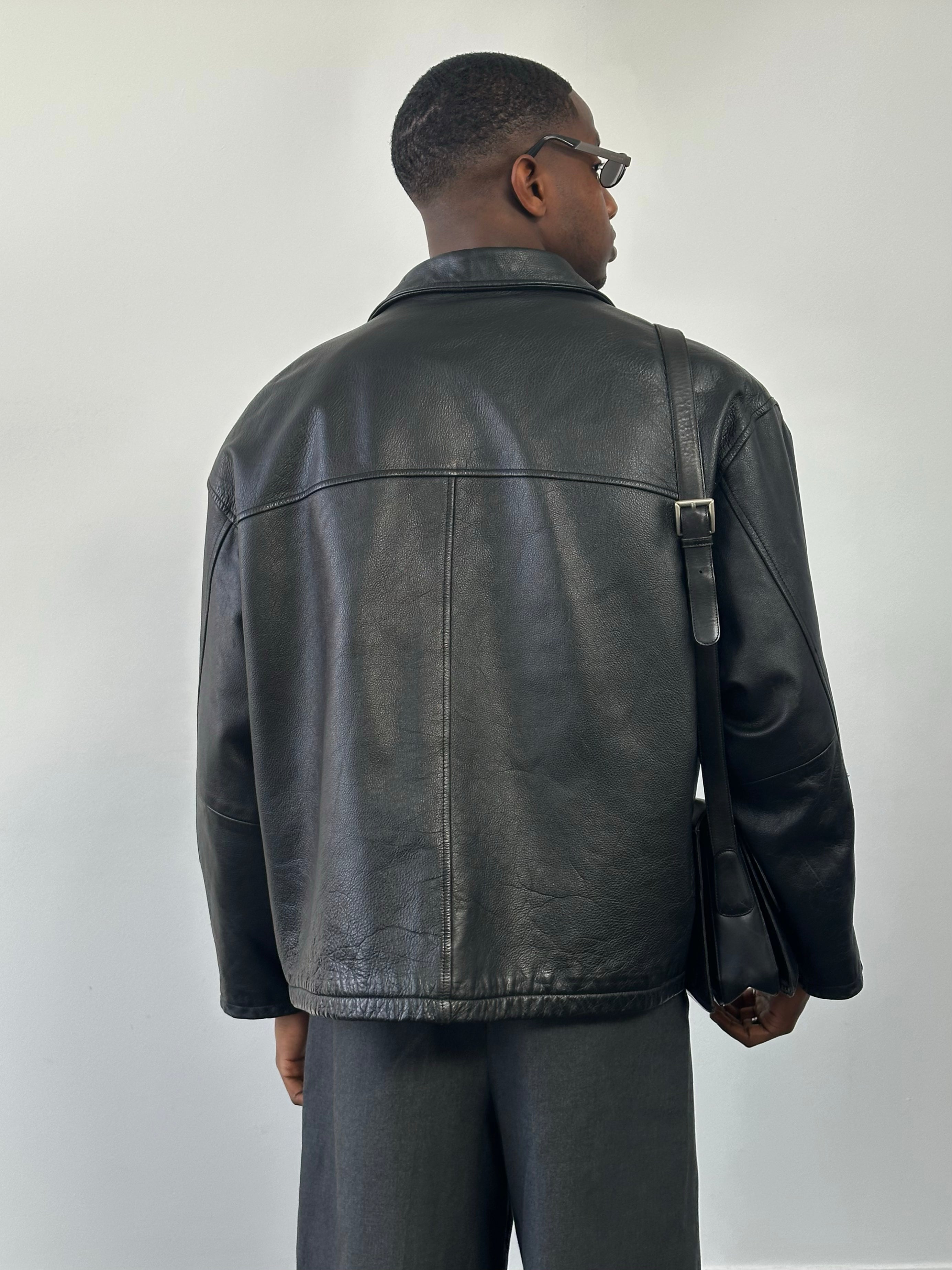 Vintage 1990s heavyweight leather jacket in black, featuring a minimal design and XXL size, with classic leather texture and details.