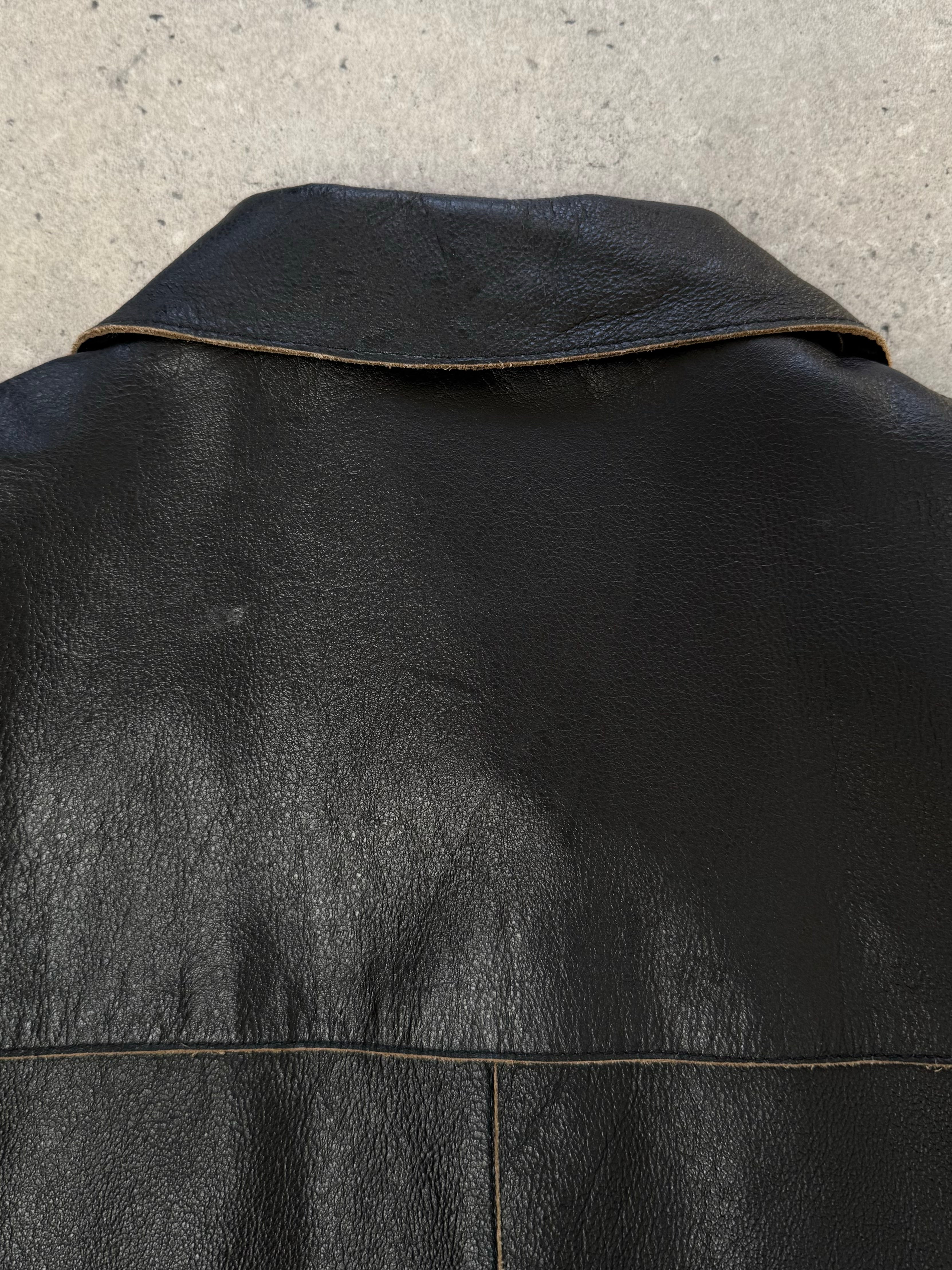 Vintage 1990s leather belted jacket, size small, featuring classic leather material and retro style, displayed on a hanger.