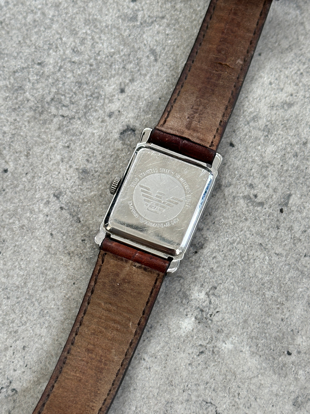 Emporio Armani 2000s leather rectangular quartz watch with a sleek black strap and minimalist dial.