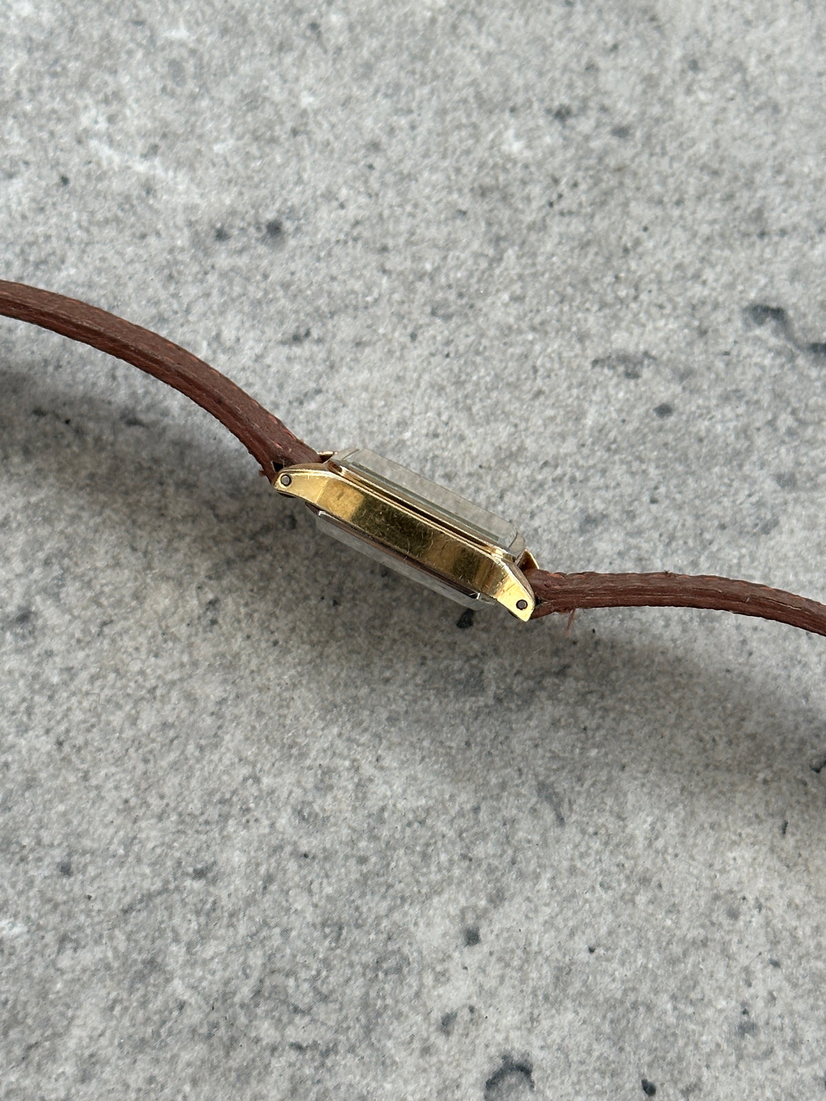 Vintage Pulsar 1980s gold-tone leather watch with a round dial and classic design, displayed on a neutral background.