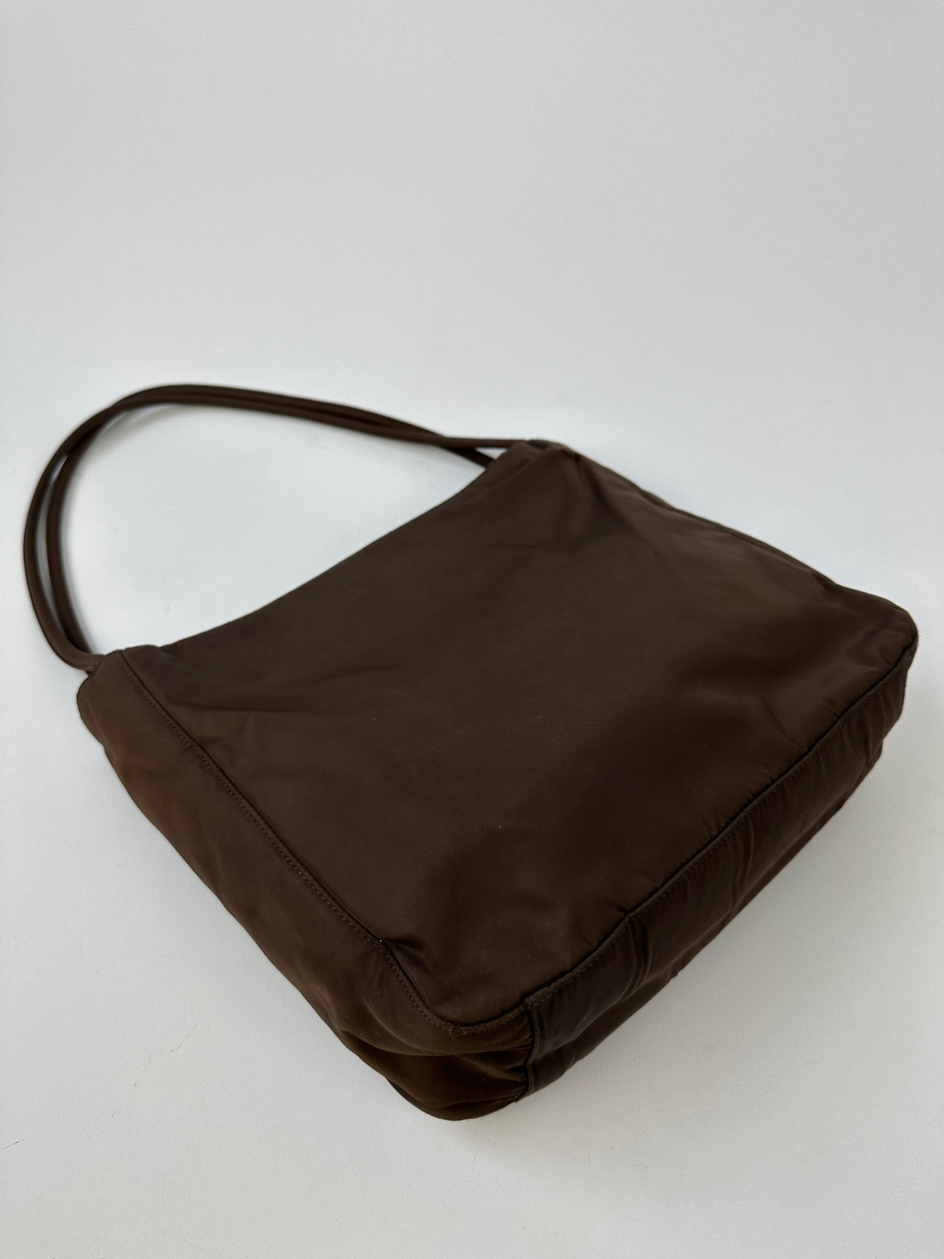 Prada Tessuto nylon tote bag with handles and spacious interior, featuring a sleek, modern design in durable fabric.