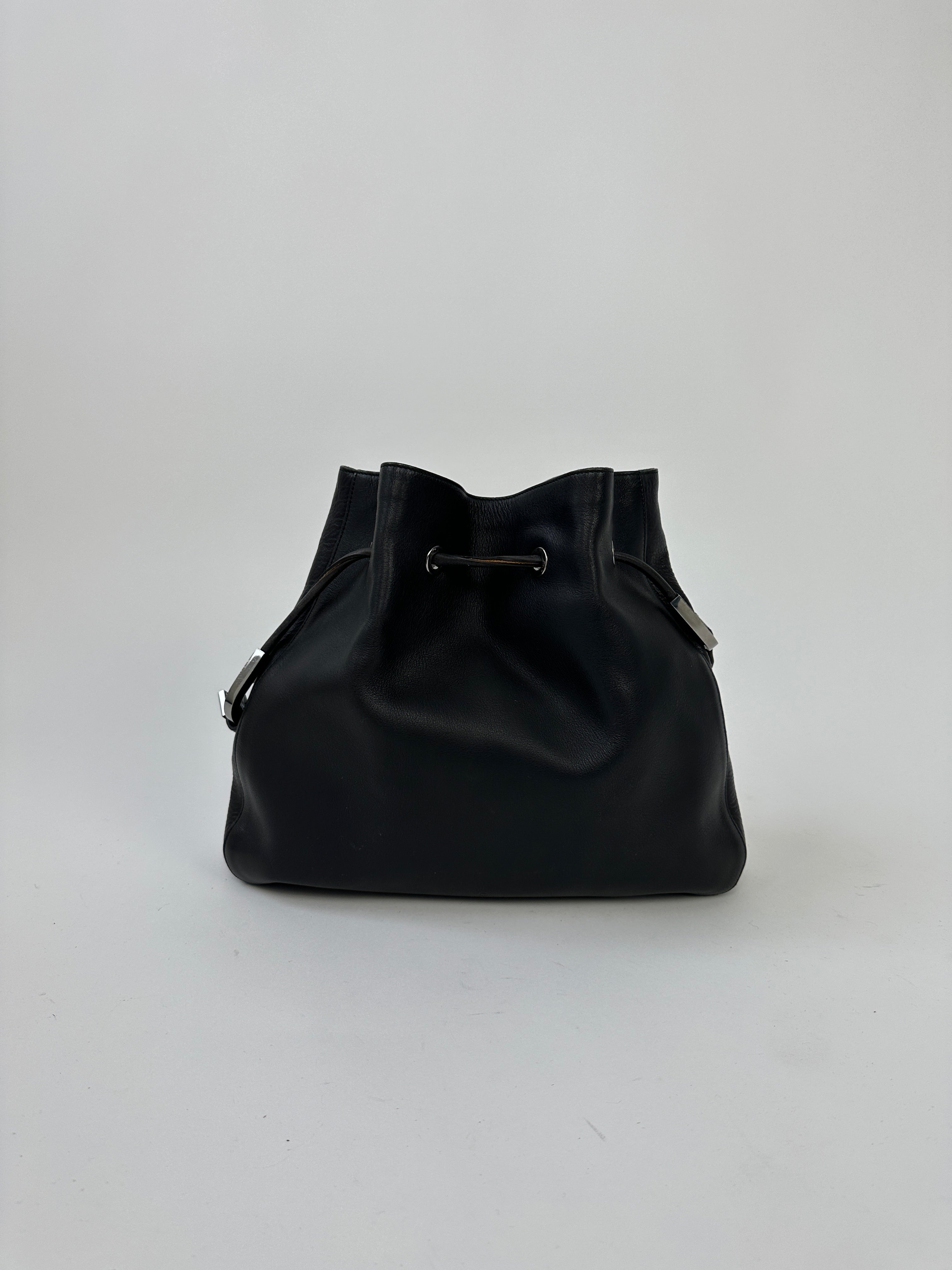 Gucci leather bucket bag with adjustable shoulder strap and gold-tone hardware, featuring a stylish, spacious design.