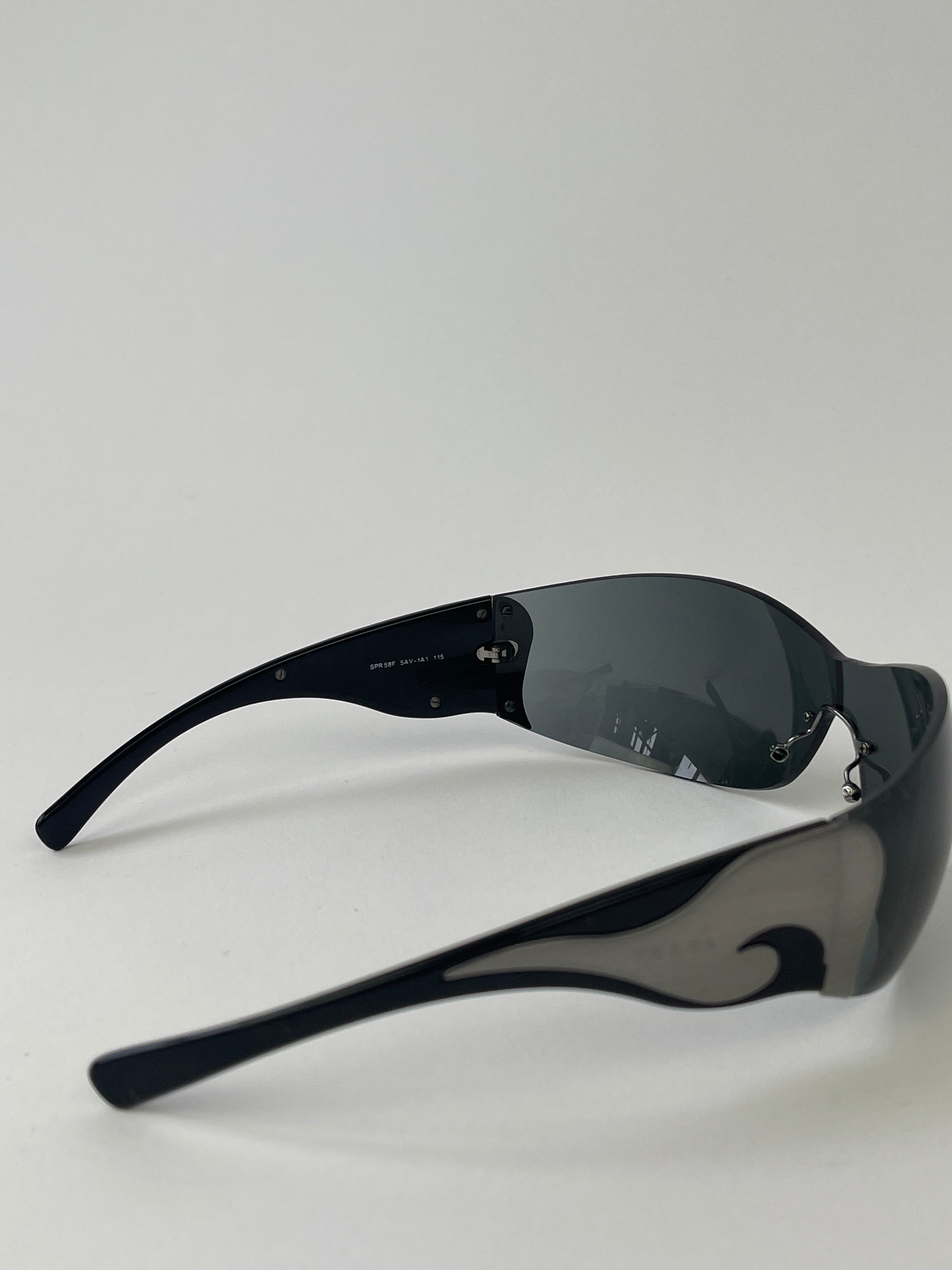 Prada Flame Rimless Wrap Sunglasses with sleek, modern design and tinted lenses, featuring a rimless frame for a stylish look.