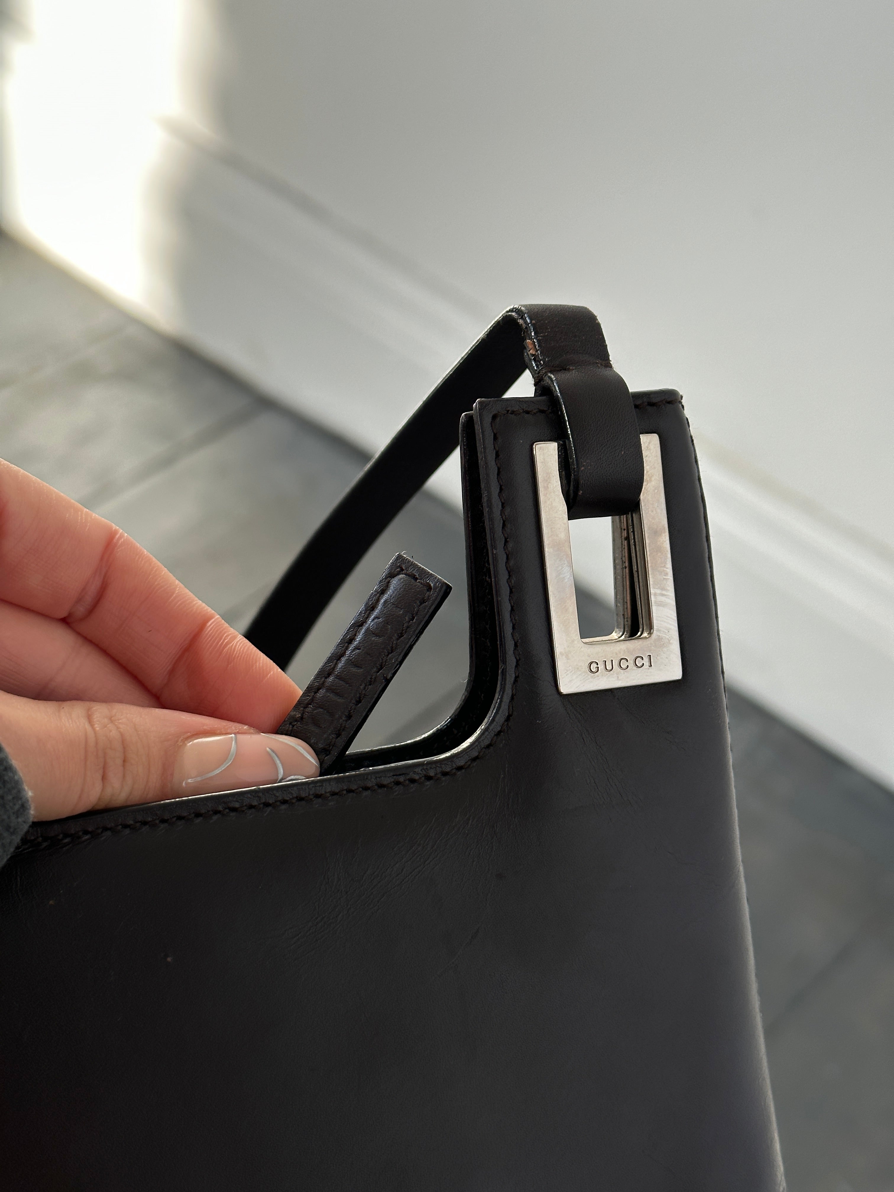 Gucci leather shoulder bag with adjustable strap and gold-tone hardware, featuring a sleek, structured design.