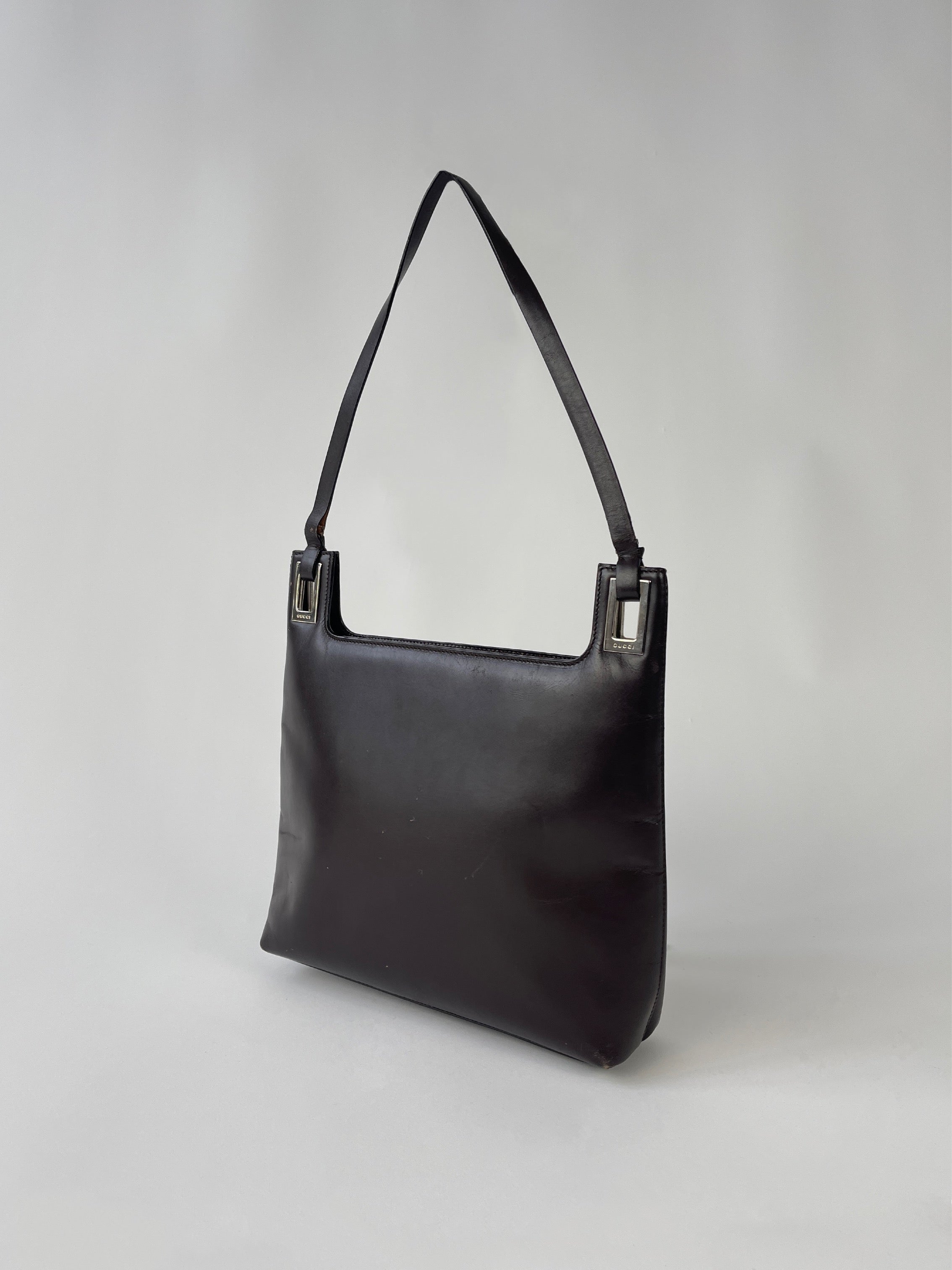 Gucci leather shoulder bag with top handle and gold-tone hardware, showcasing a sleek and stylish design.