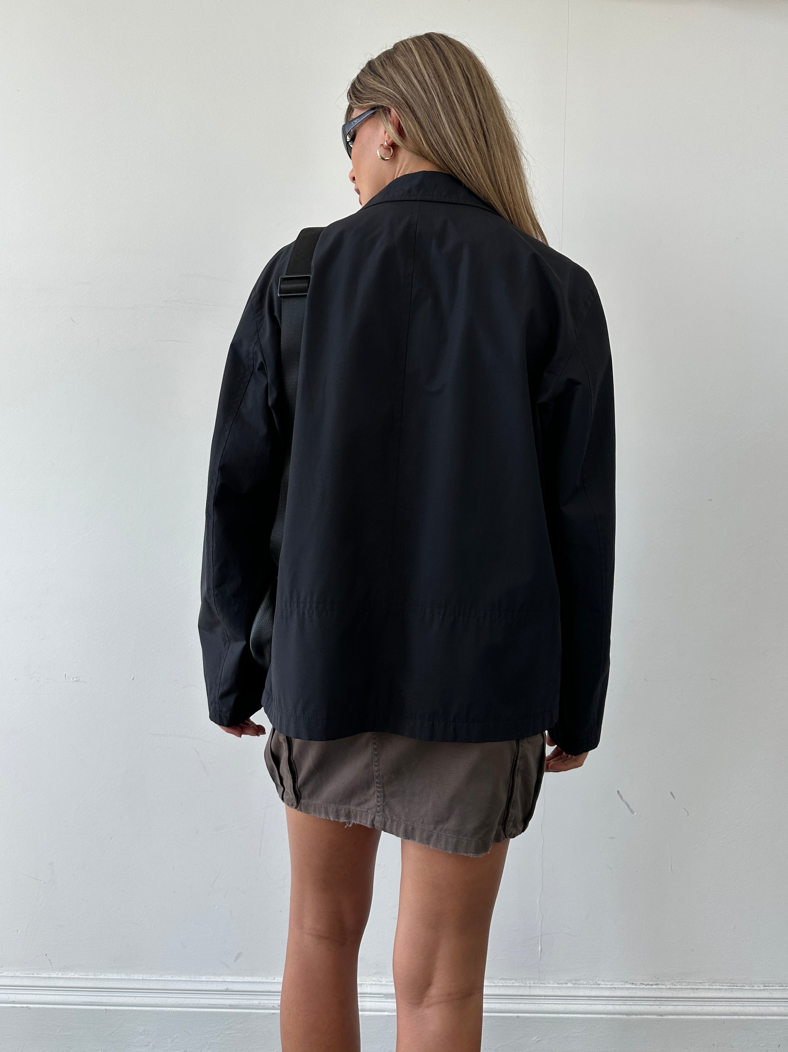 Hugo Boss minimal zip-up jacket in size L, featuring a sleek design and full front zipper, displayed on a hanger.