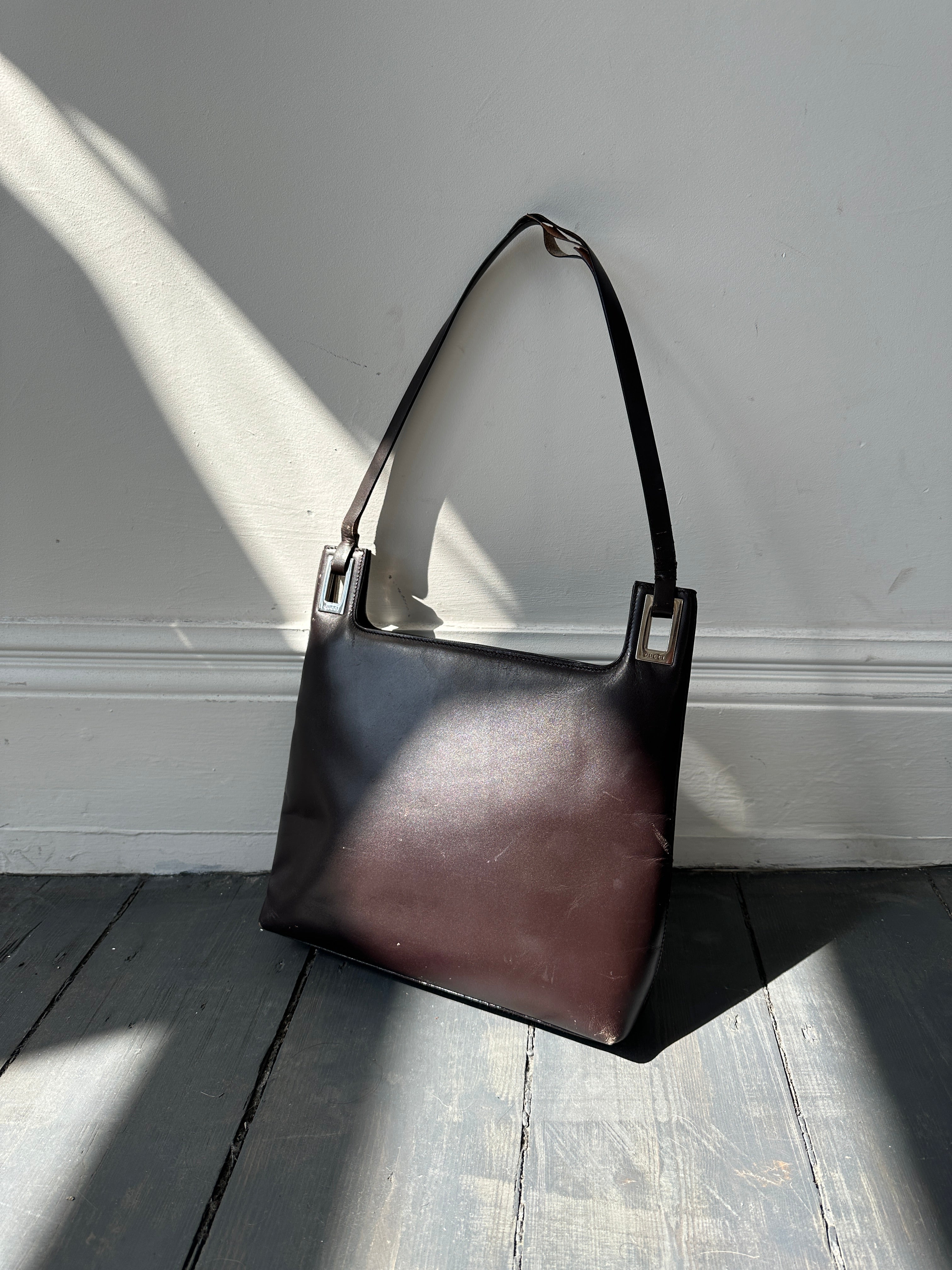 Gucci leather shoulder bag with adjustable strap and signature design, stylish accessory for everyday or formal wear.