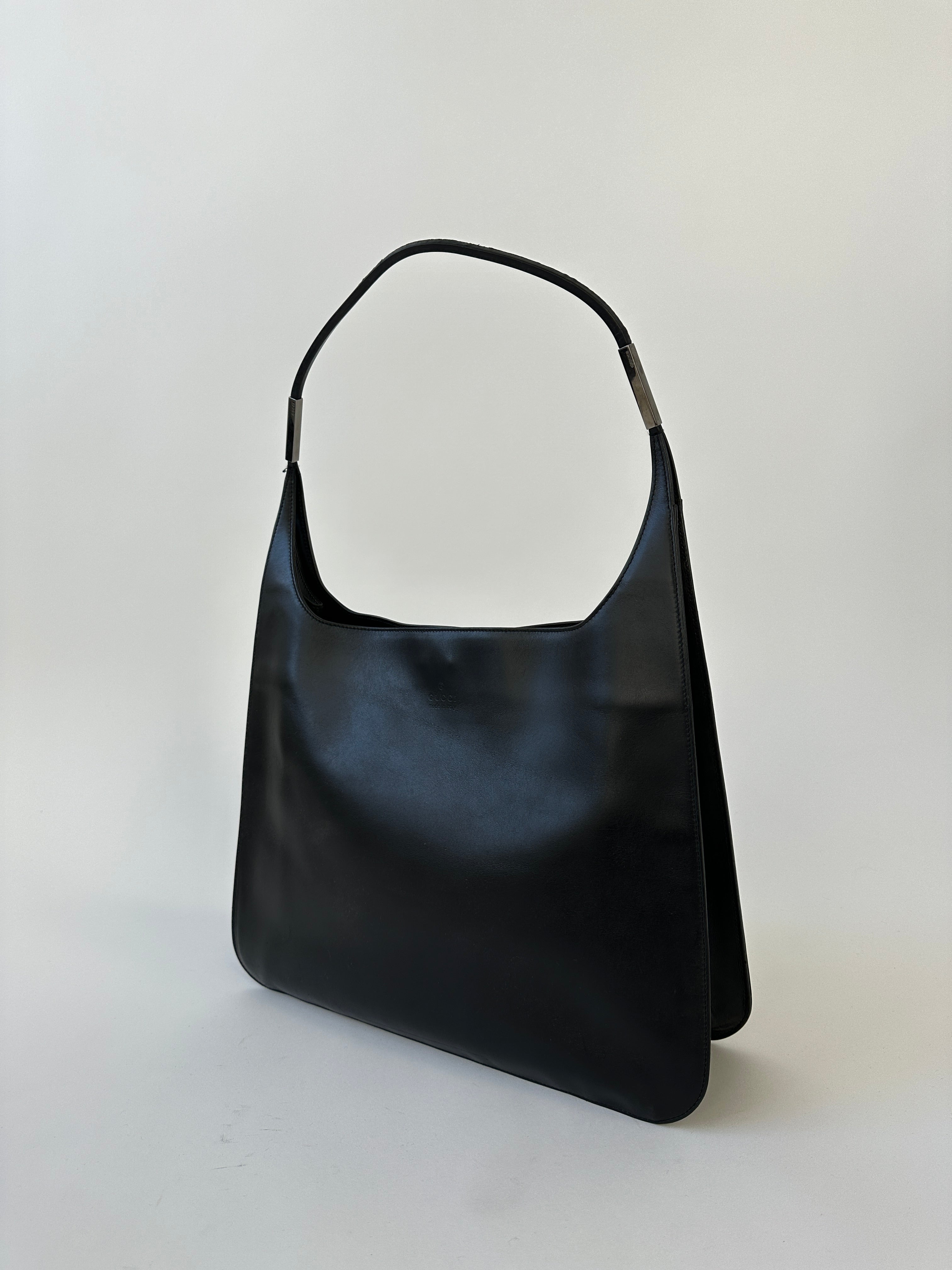 Gucci leather shoulder bag with adjustable strap and signature design, showcasing premium craftsmanship and stylish accessory details.