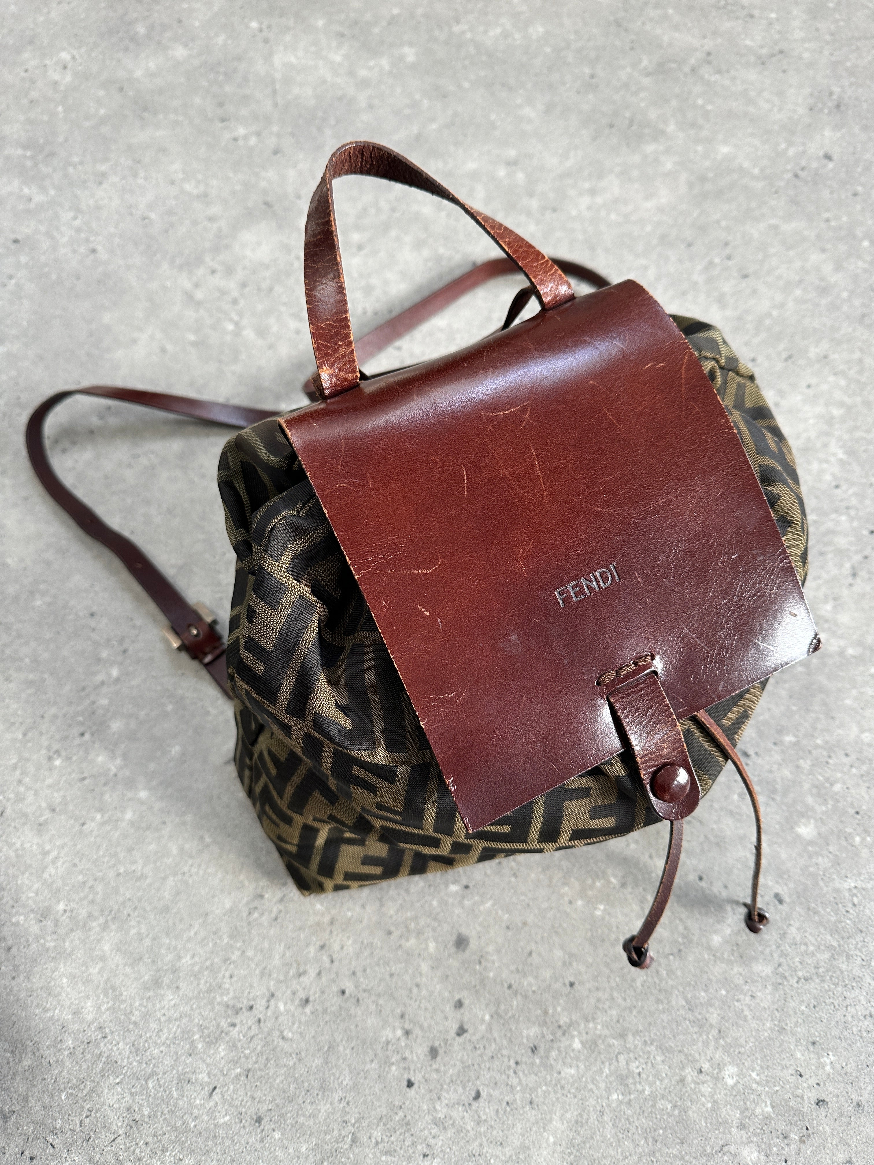 Fendi Zucca FF monogram rucksack bag with leather straps and front pocket, featuring iconic Fendi logo pattern and adjustable shoulder straps.