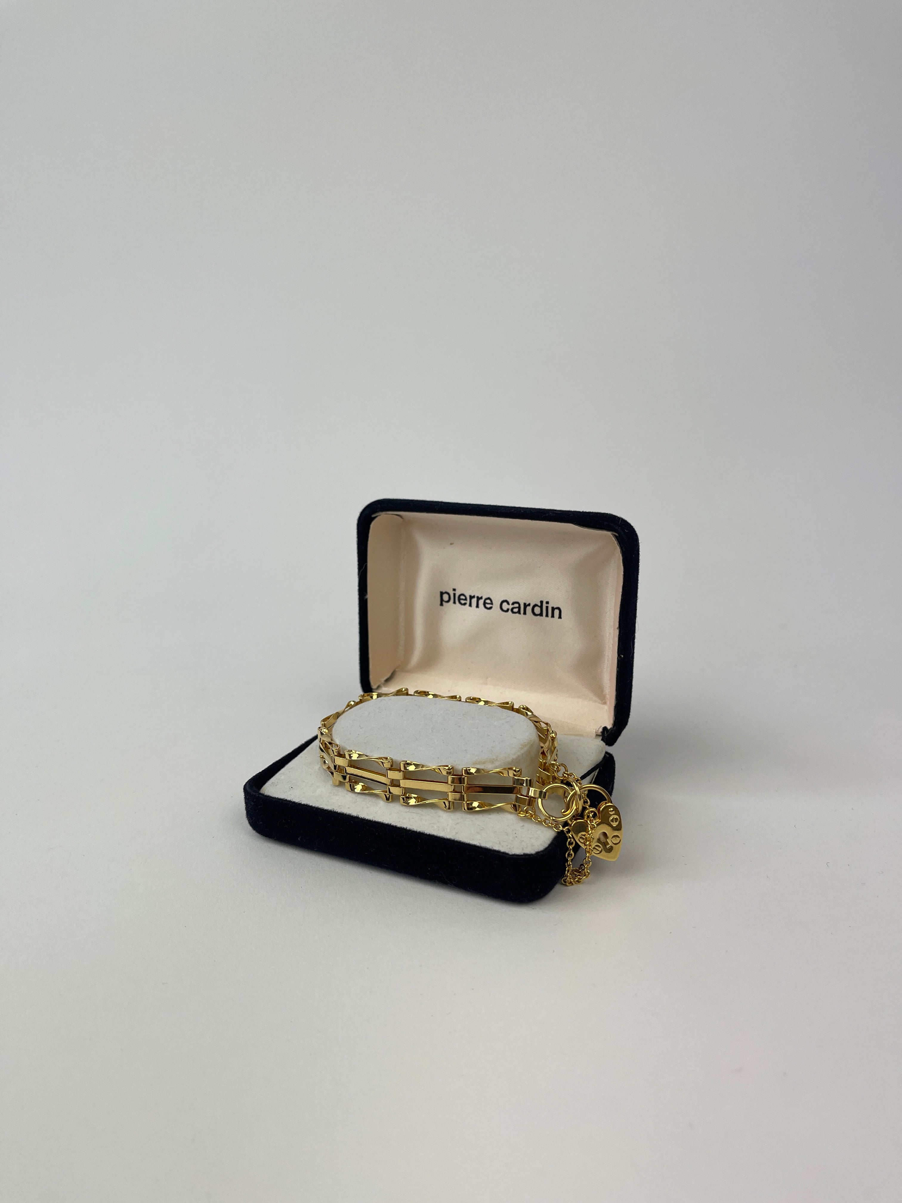 Gold plated Pierre Cardin bracelet with sleek design and polished finish, displayed on a white background.