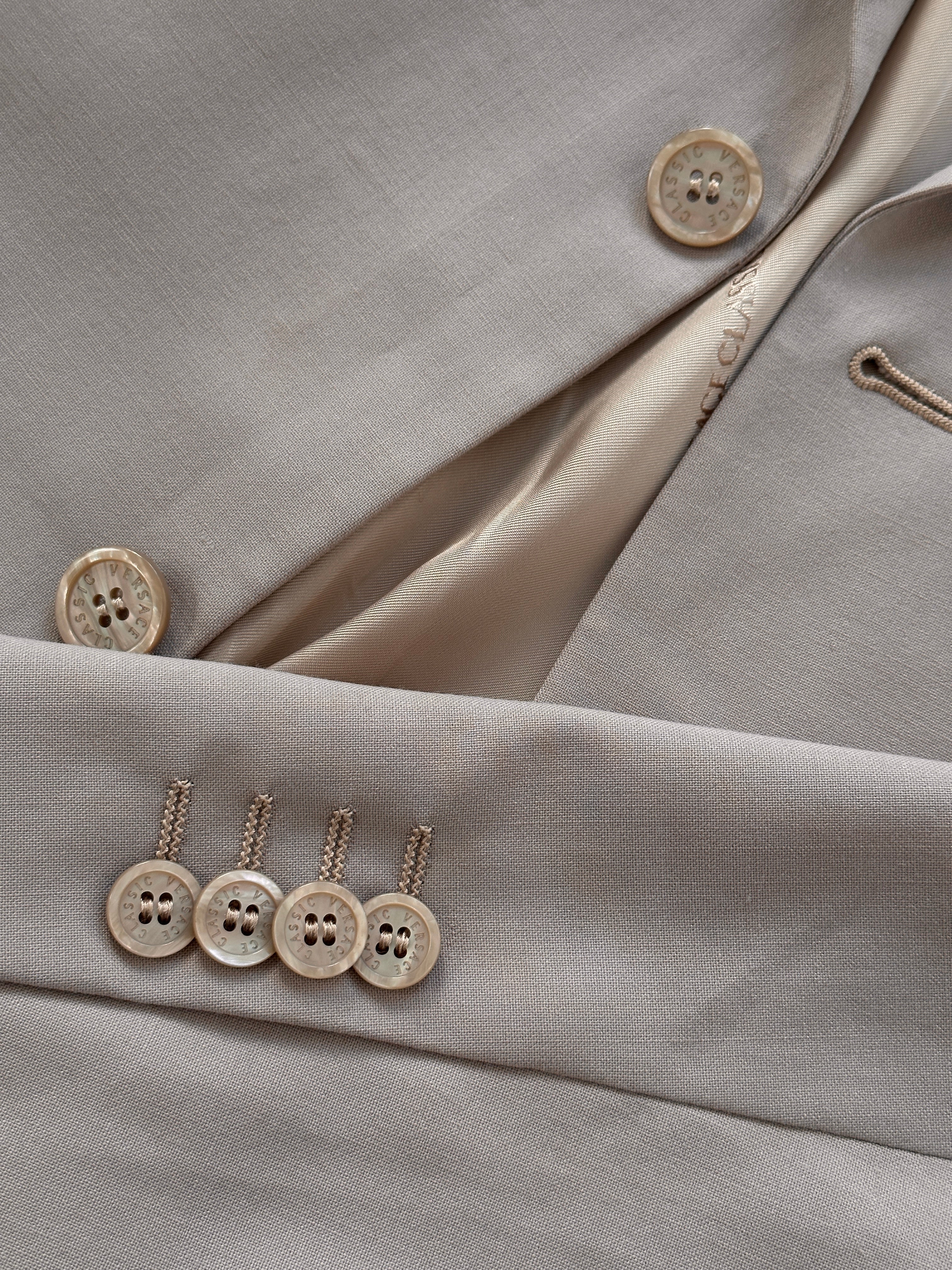 Versace single-breasted wool jumpsuit in size 42R/W30, tailored fit with lapel collar, displayed on a neutral background.