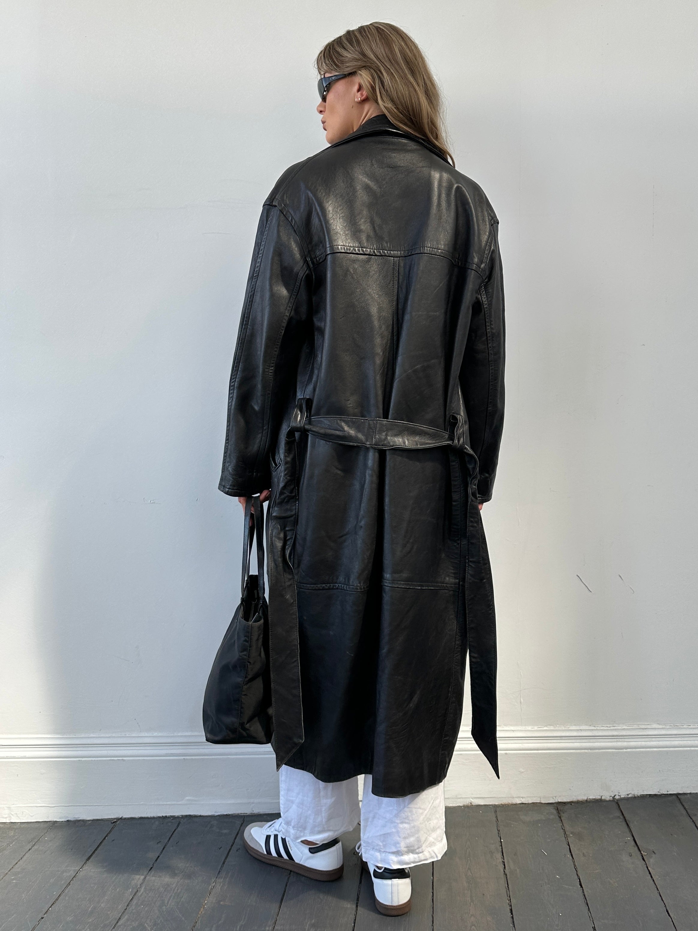 Vintage belted leather floor-length coat, full-length jacket with classic design, displayed on a hanger.
