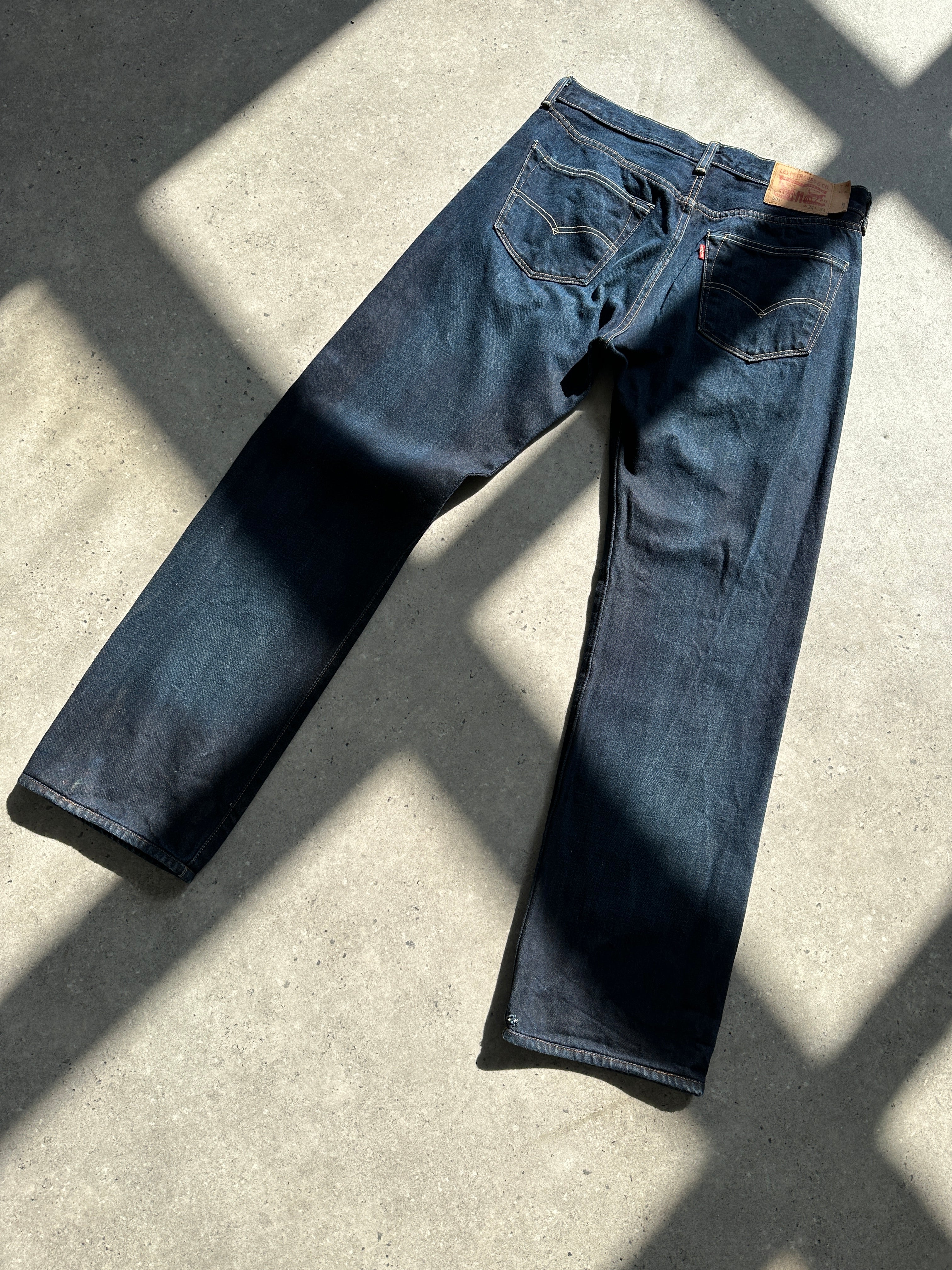 Levi’s 501 dark wash denim jeans with straight leg fit, size W30, shown on a model with front pockets and classic stitching.