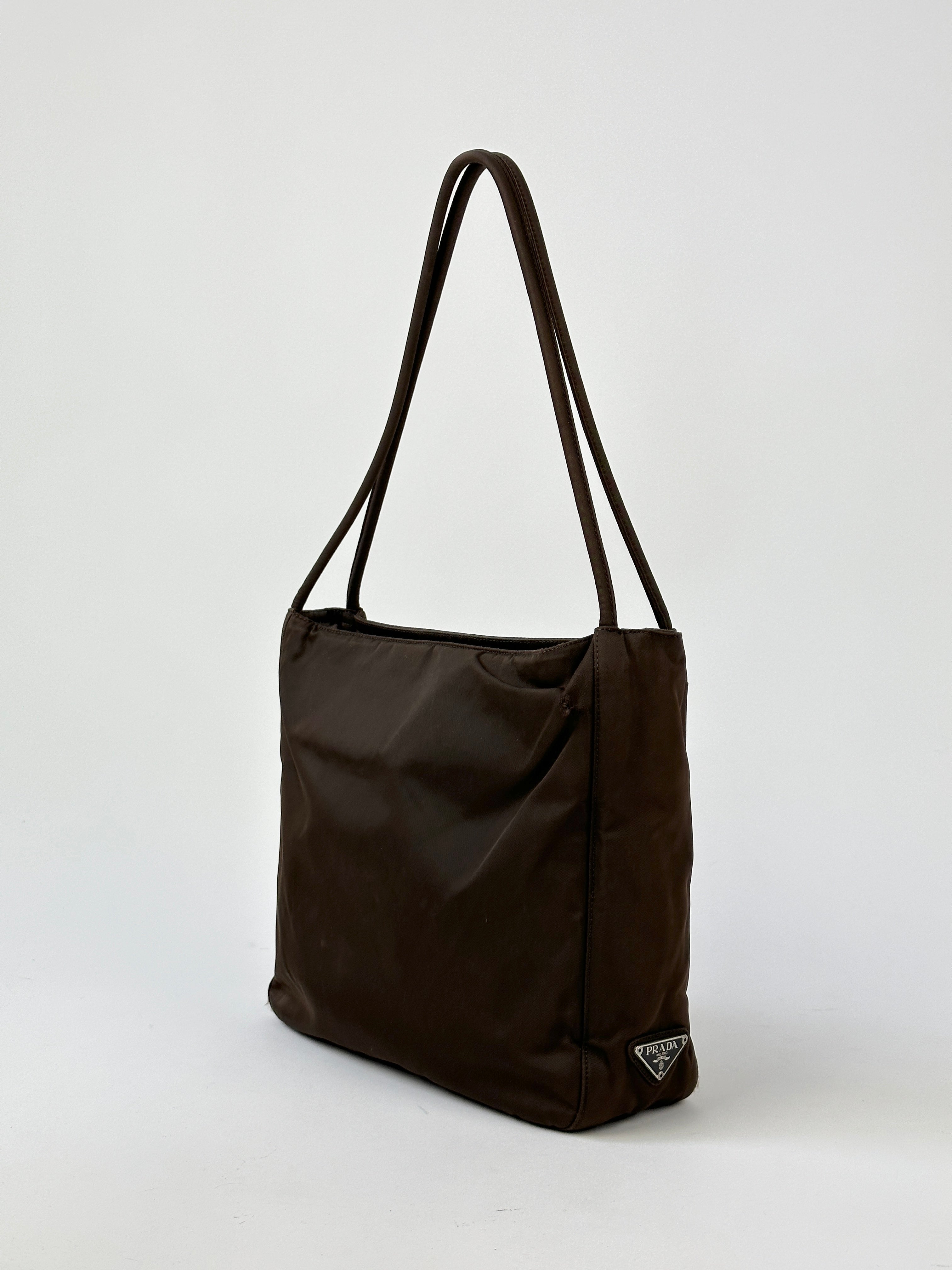 Prada Tessuto nylon tote bag with sturdy handles and spacious interior, showcasing sleek design and durable fabric.