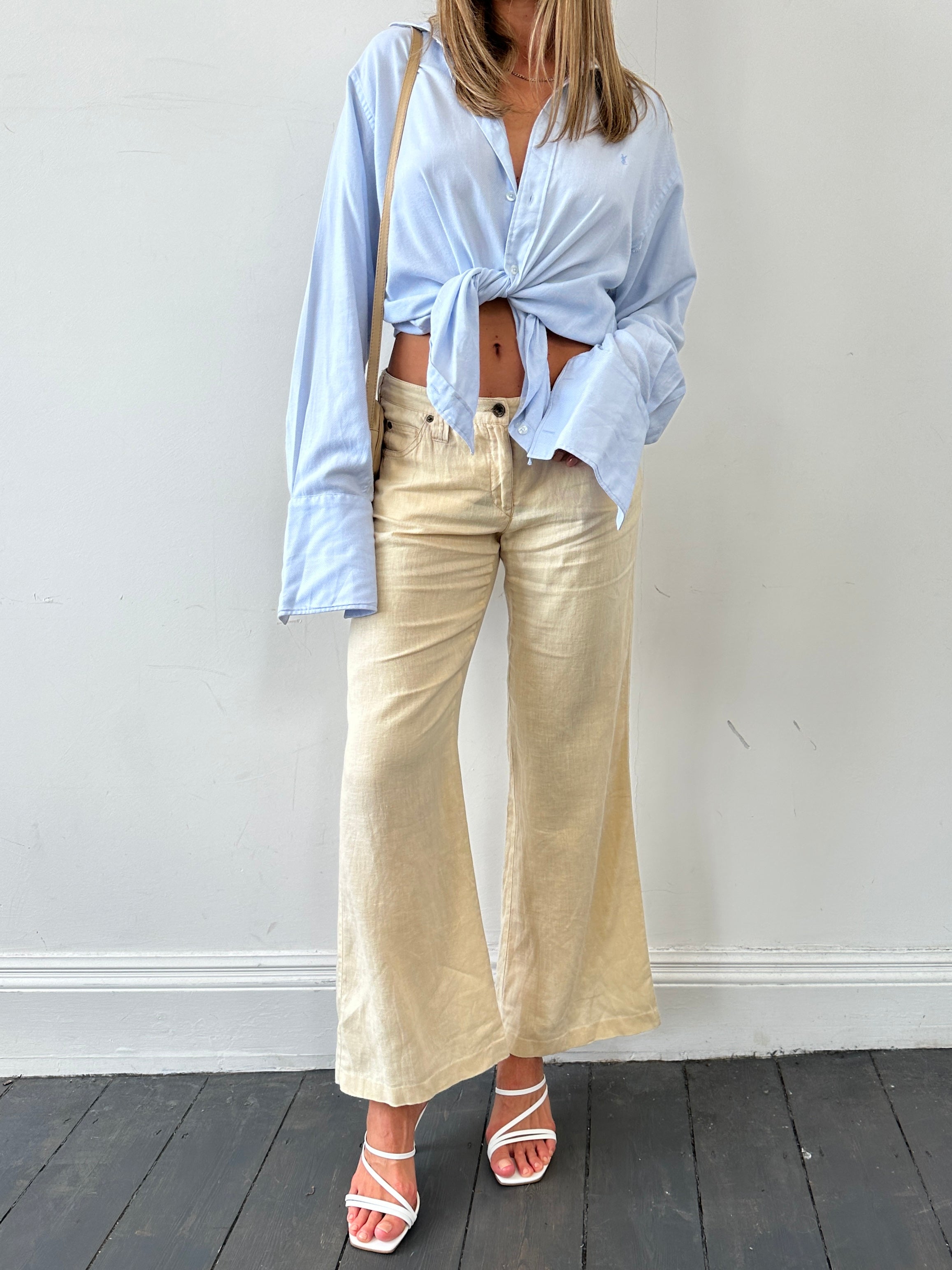 Armani Jeans low rise pure linen flared trousers in light color, showing the waistband and full length on a model.