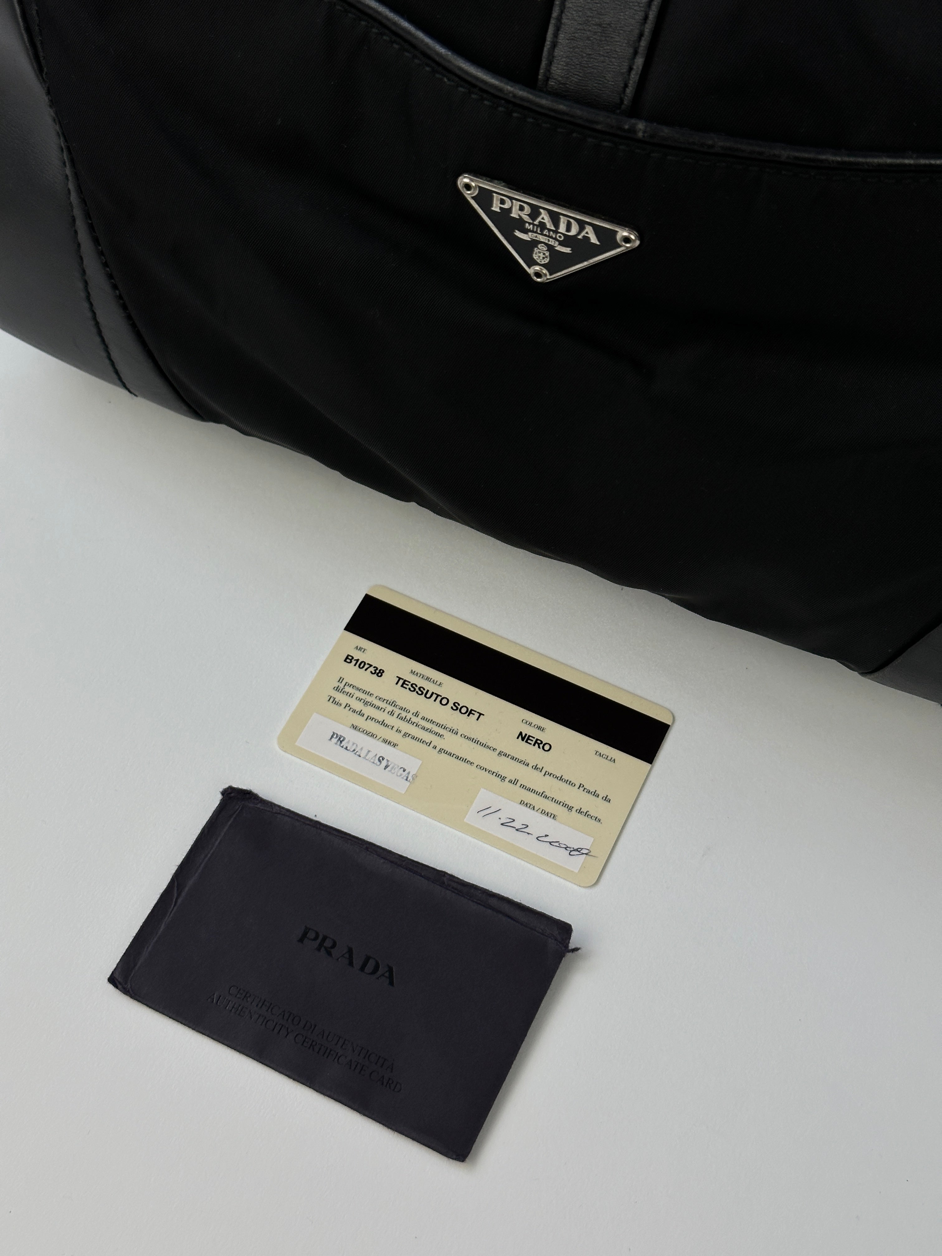 Prada 2000s Tessuto nylon double-sided shoulder bag with adjustable strap and sleek design, featuring Prada branding and durable material.
