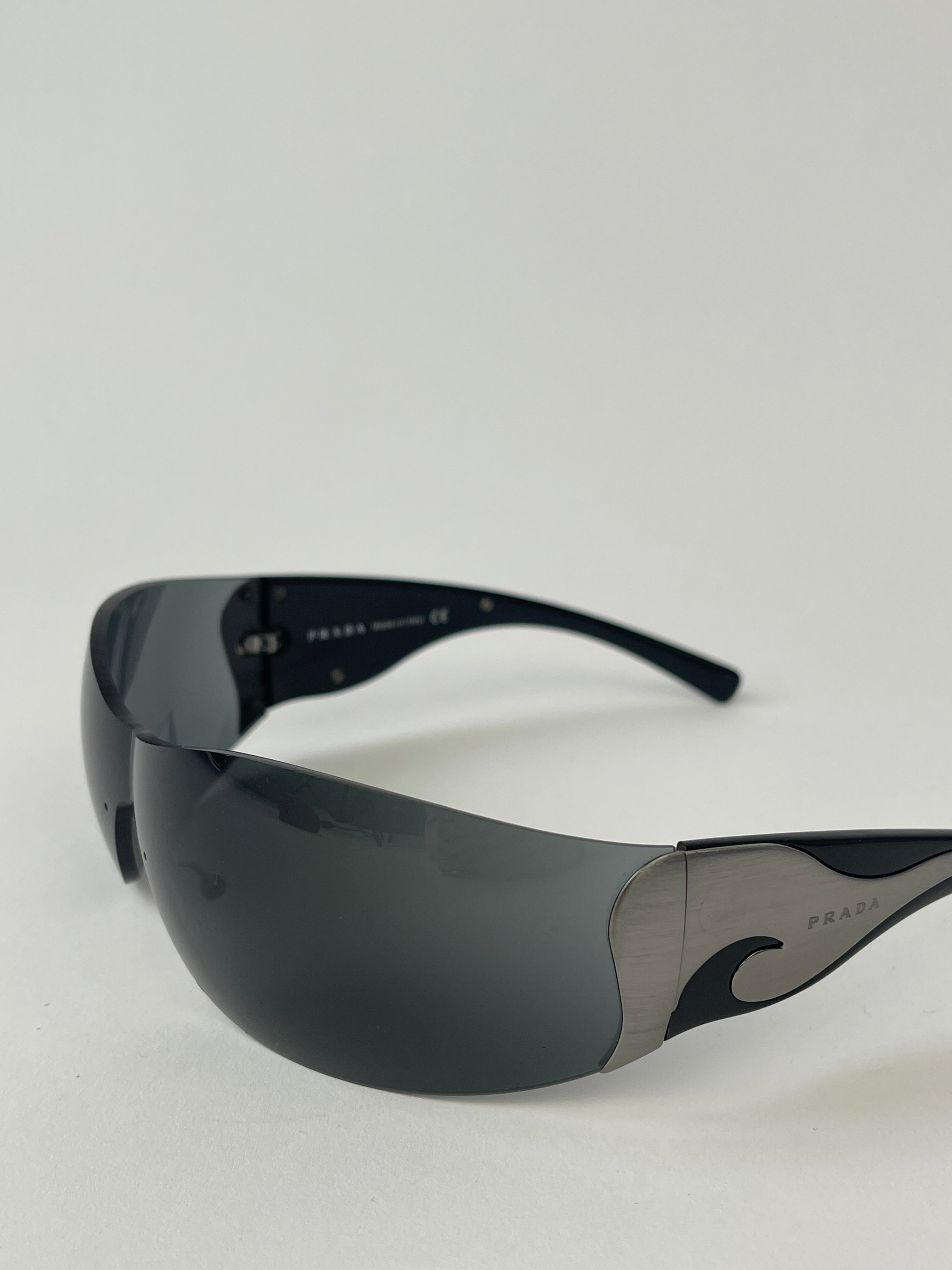 Prada Flame Rimless Wrap Sunglasses with sleek, modern design and tinted lenses, lightweight rimless frame for stylish eye protection.