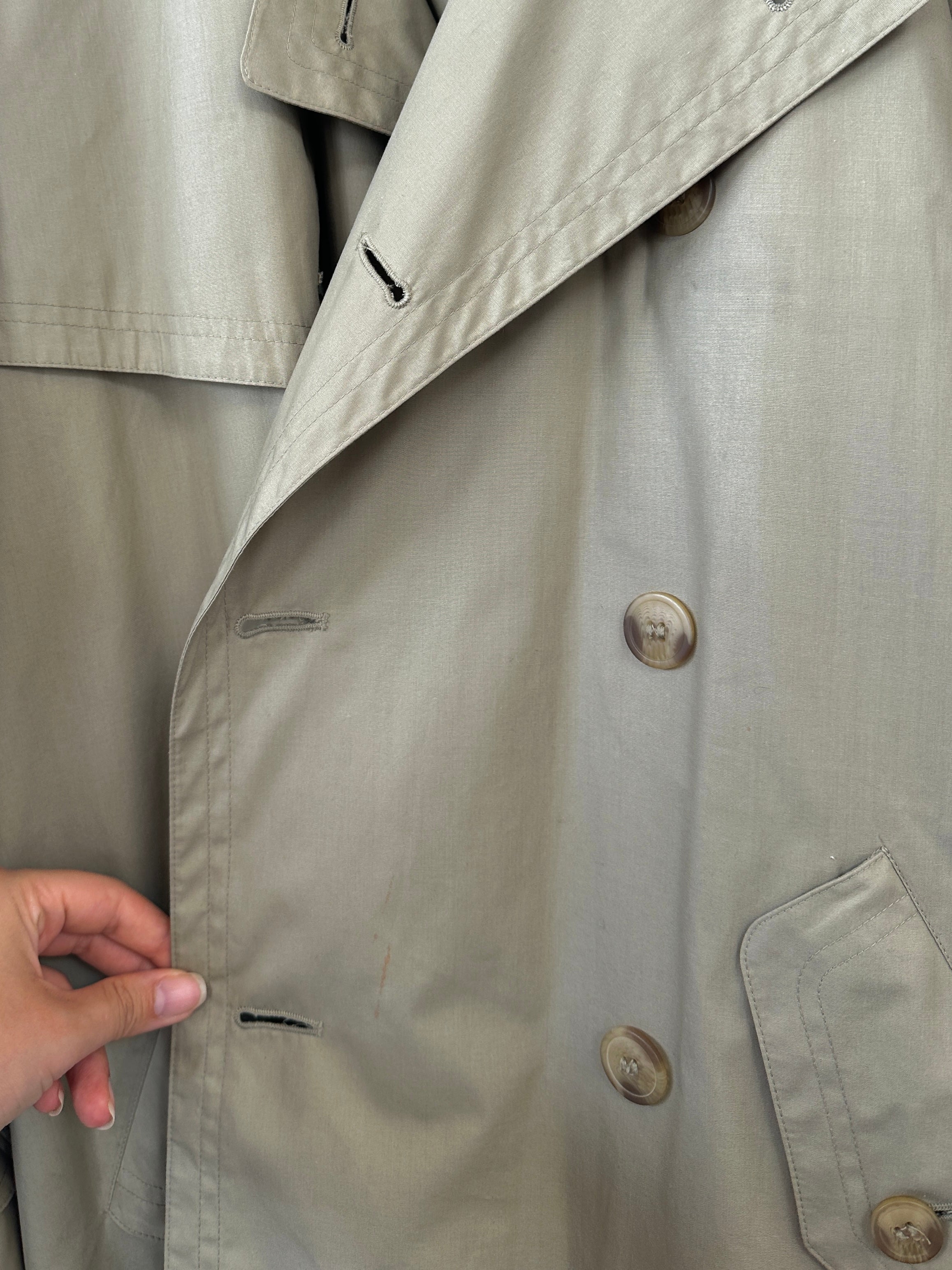 Yves Saint Laurent double-breasted trench coat in size L/XL, featuring classic design and tailored fit, displayed on a hanger.