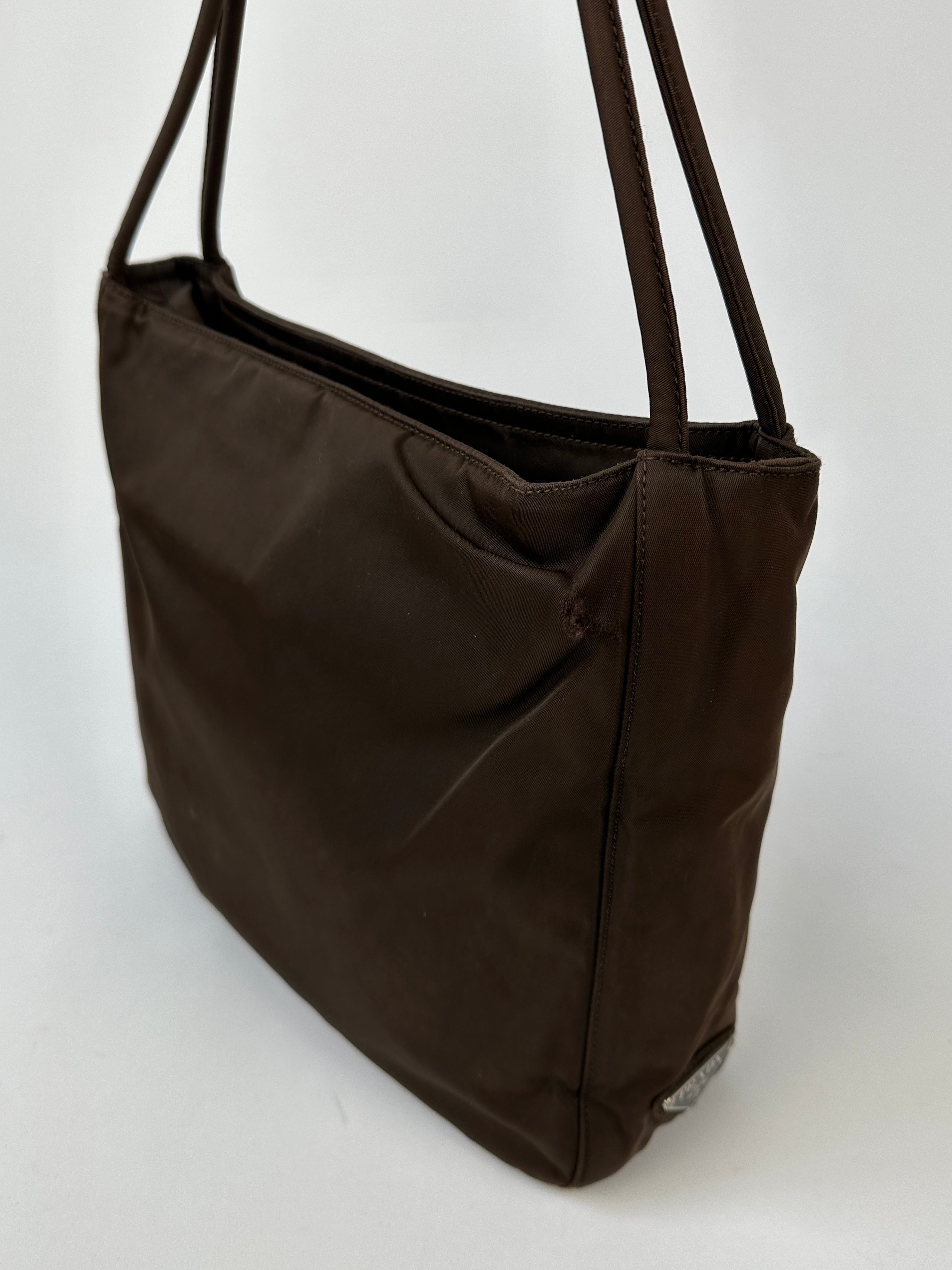 Prada Tessuto nylon tote bag with two handles and spacious interior, featuring the Prada logo on the front.