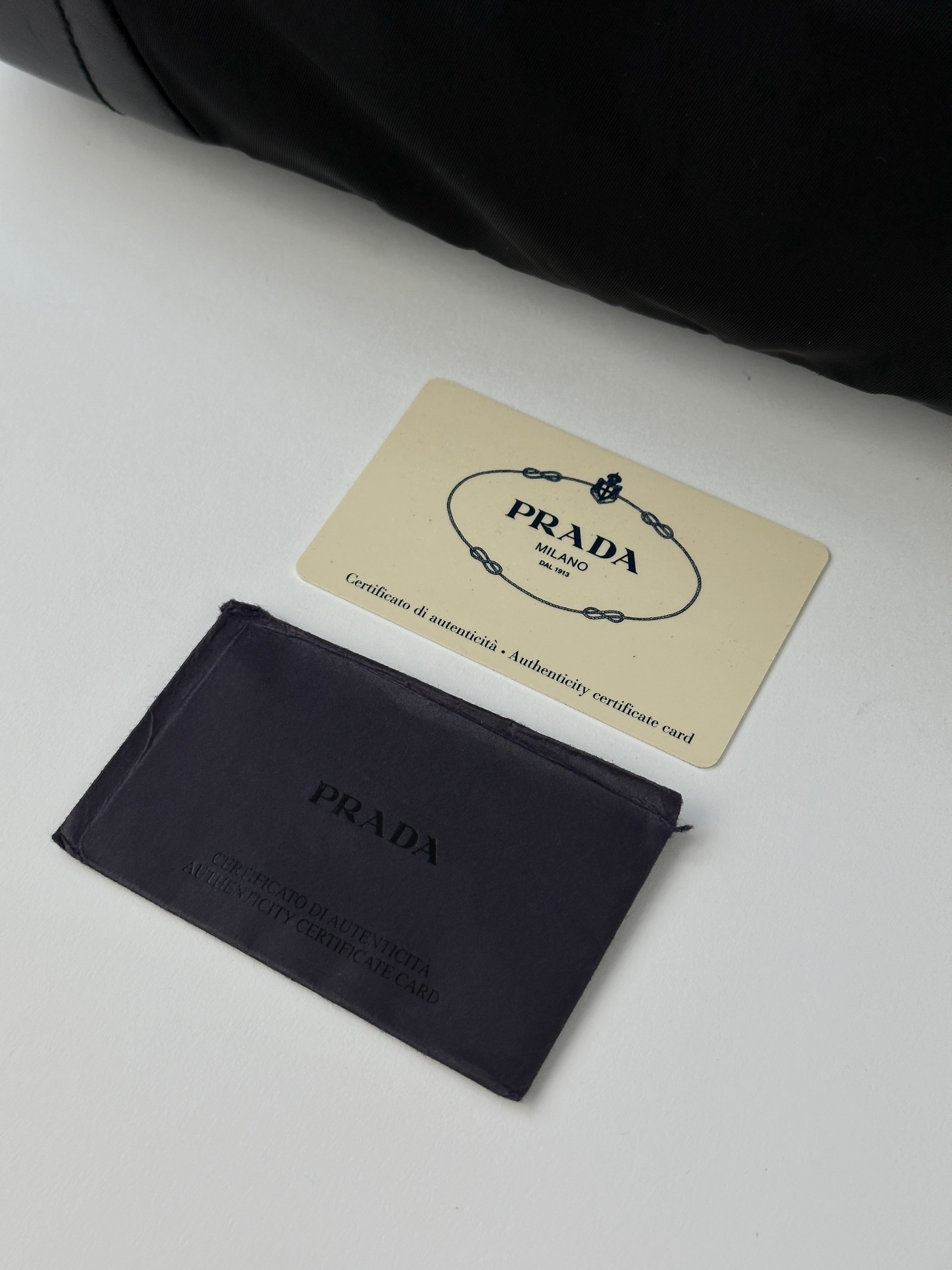 Prada 2000s Tessuto nylon double-sided shoulder bag with sleek design and adjustable strap, featuring Prada branding on the exterior.