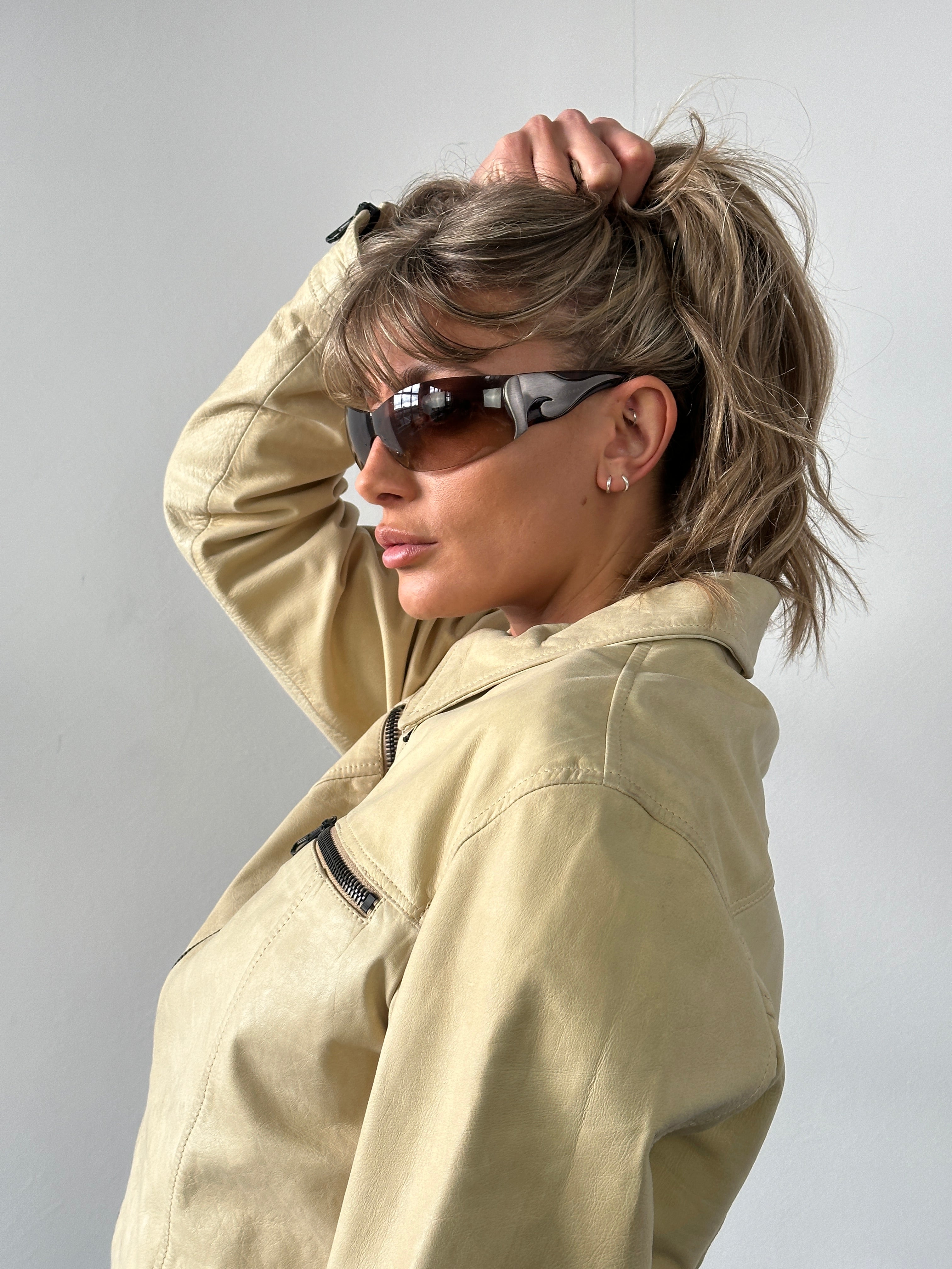 Prada Flame Rimless Wrap Sunglasses with sleek design, transparent lenses, and lightweight frame, stylishly displayed.