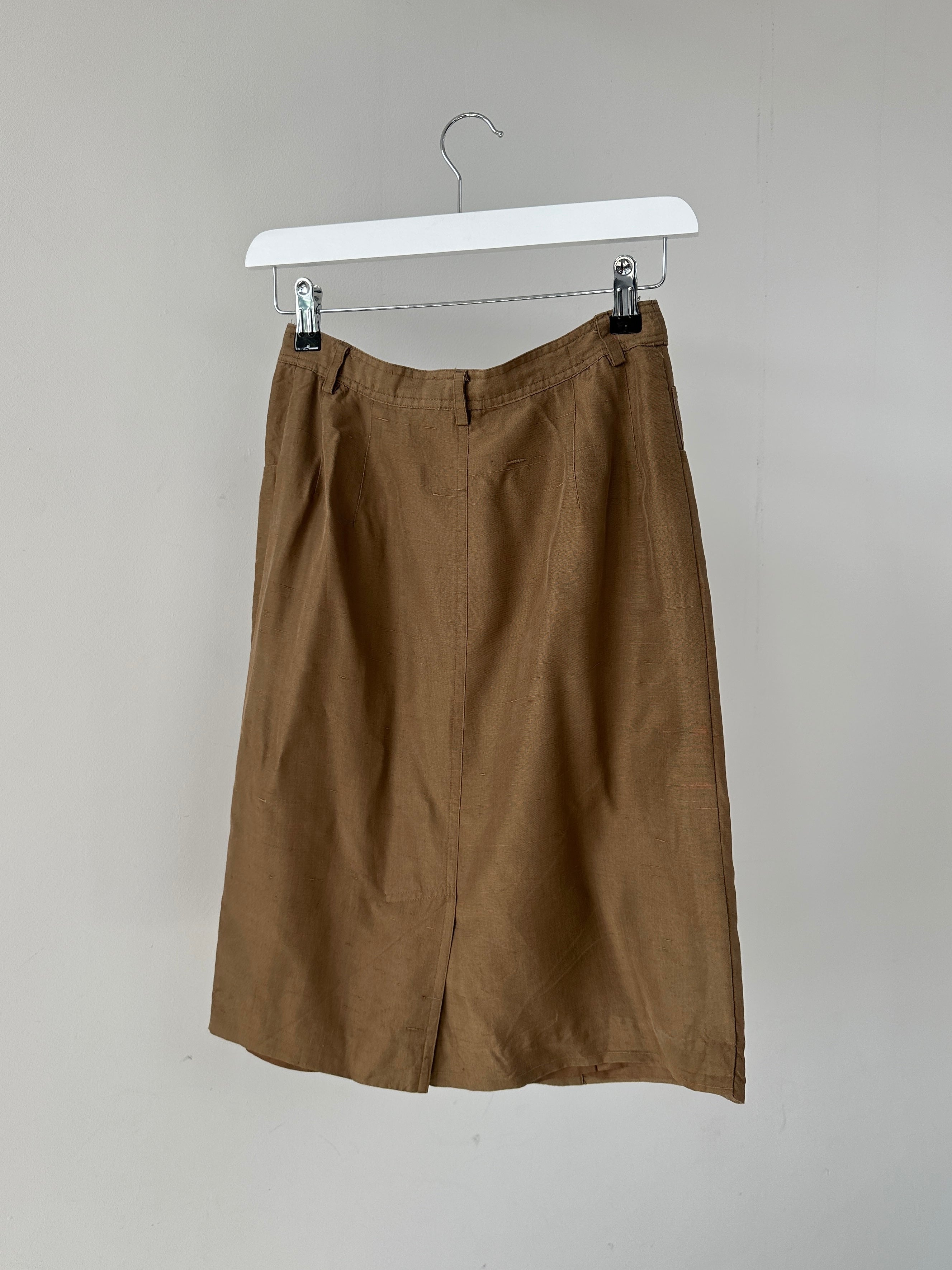 Jaeger pure silk button-down midi skirt in W24, featuring a sleek design and elegant fabric, displayed on a model.