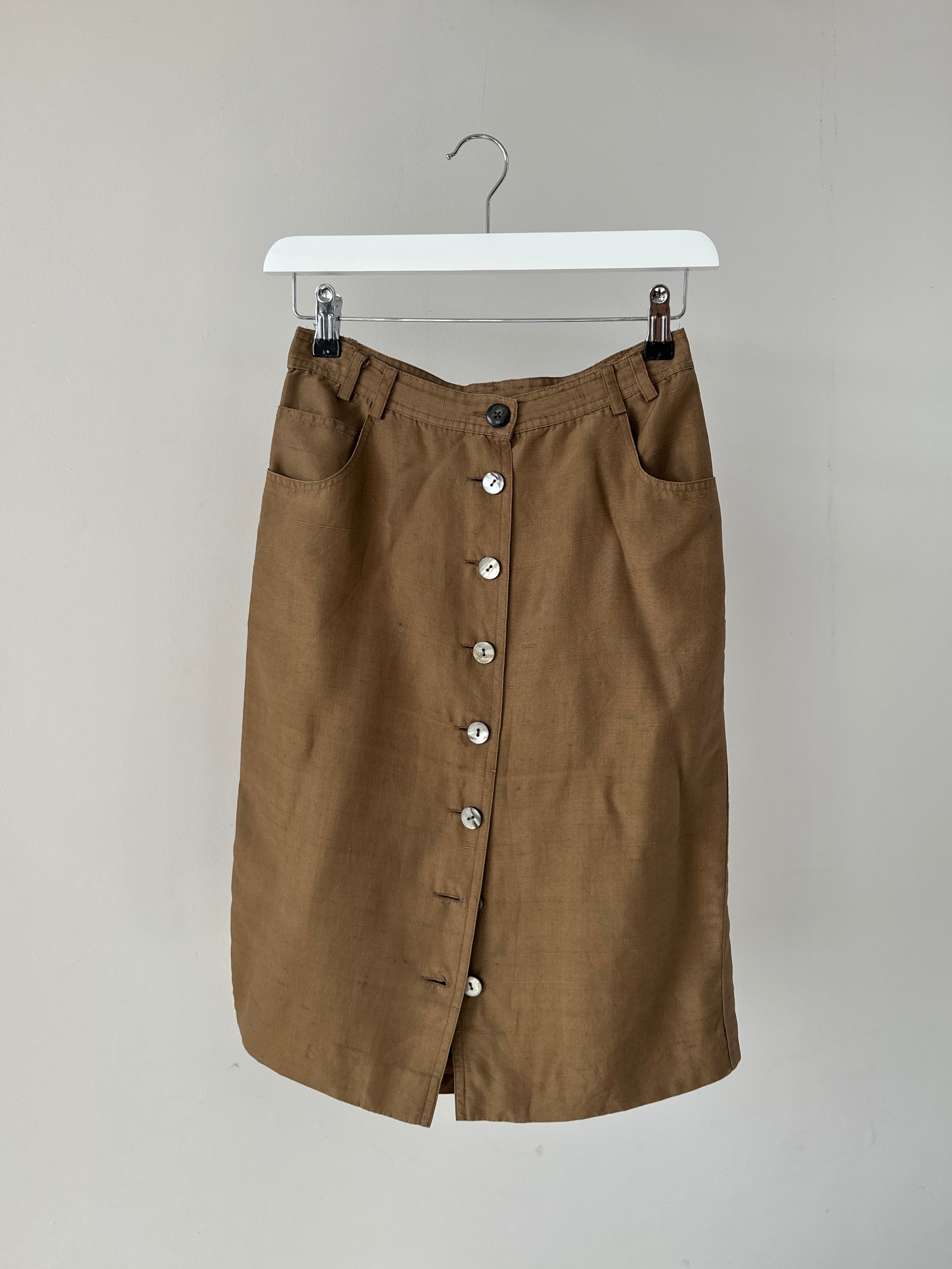 Jaeger pure silk button-down midi skirt in W24, featuring a sleek design with buttons down the front and a smooth silk texture.