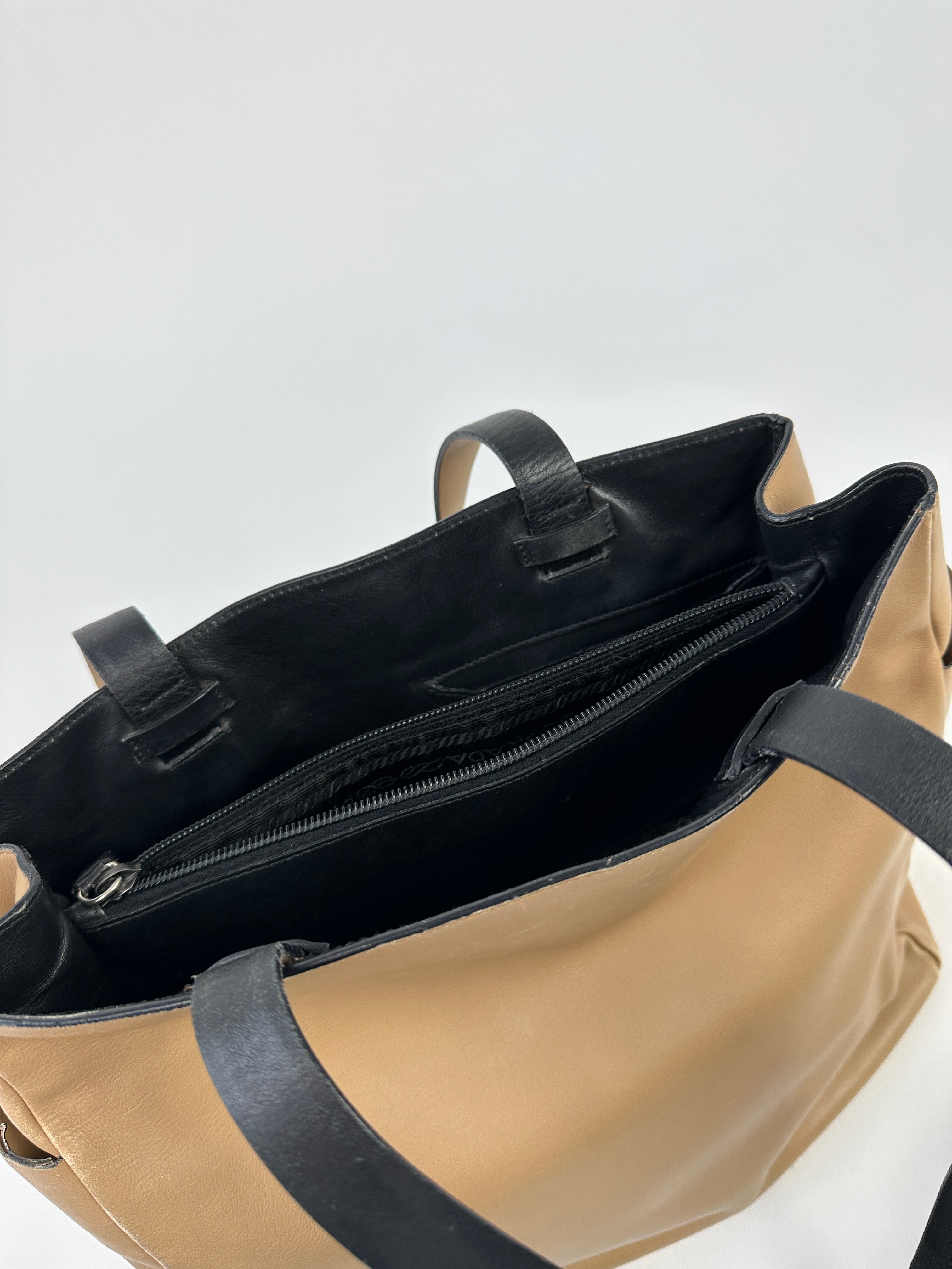 Prada contrast leather tote bag with sleek design, featuring smooth leather with contrasting accents and spacious interior.