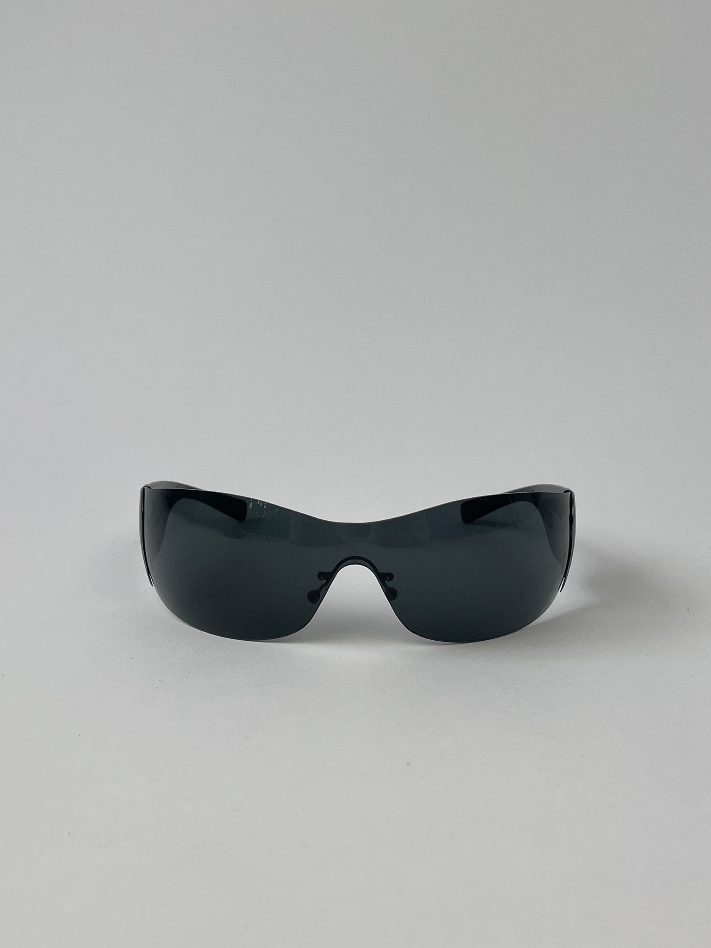 Prada Flame Rimless Wrap Sunglasses with sleek, modern design and tinted lenses, offering stylish sun protection.