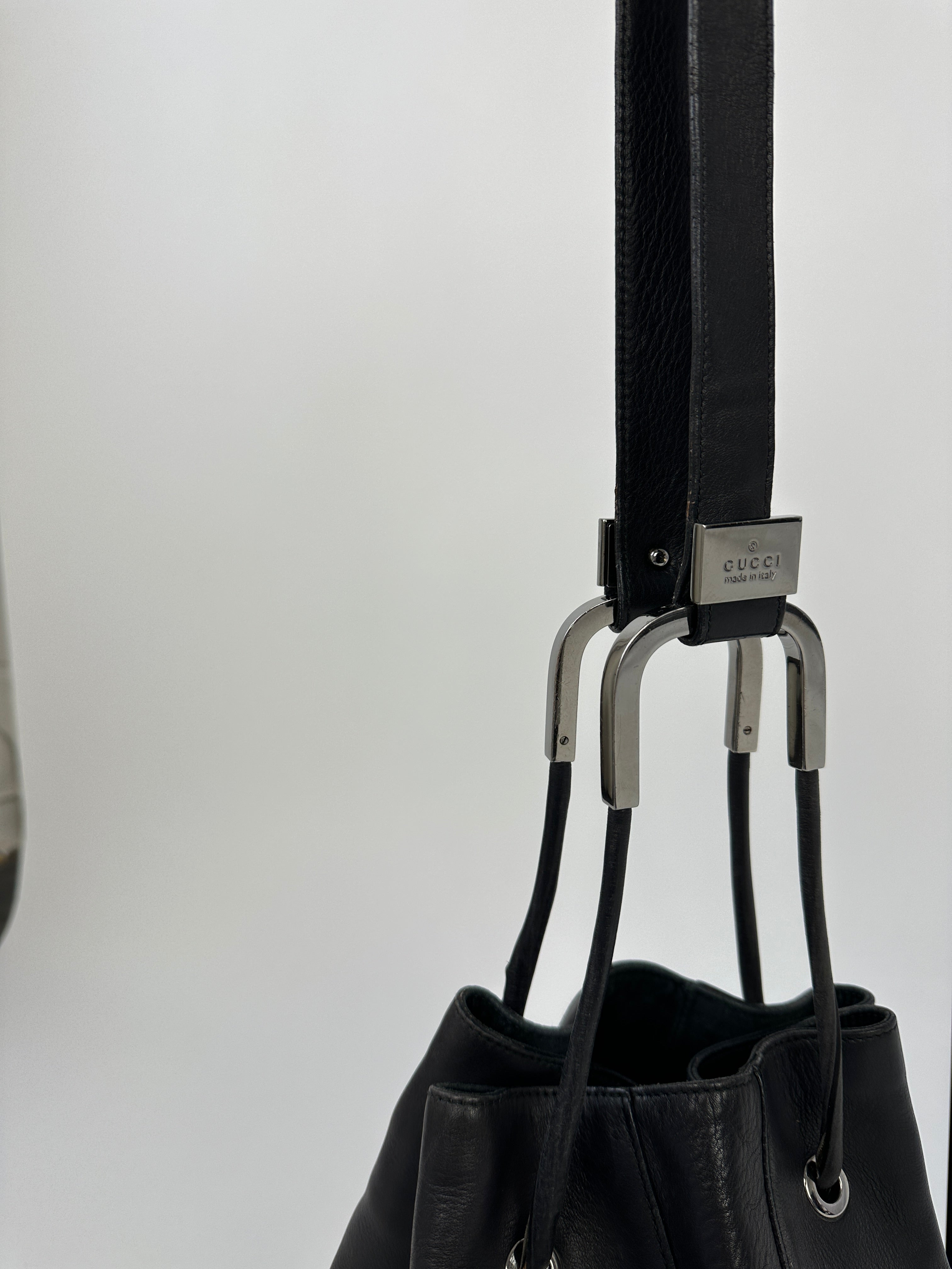 Gucci leather bucket bag with adjustable strap and gold-tone hardware, stylish and spacious for everyday use.