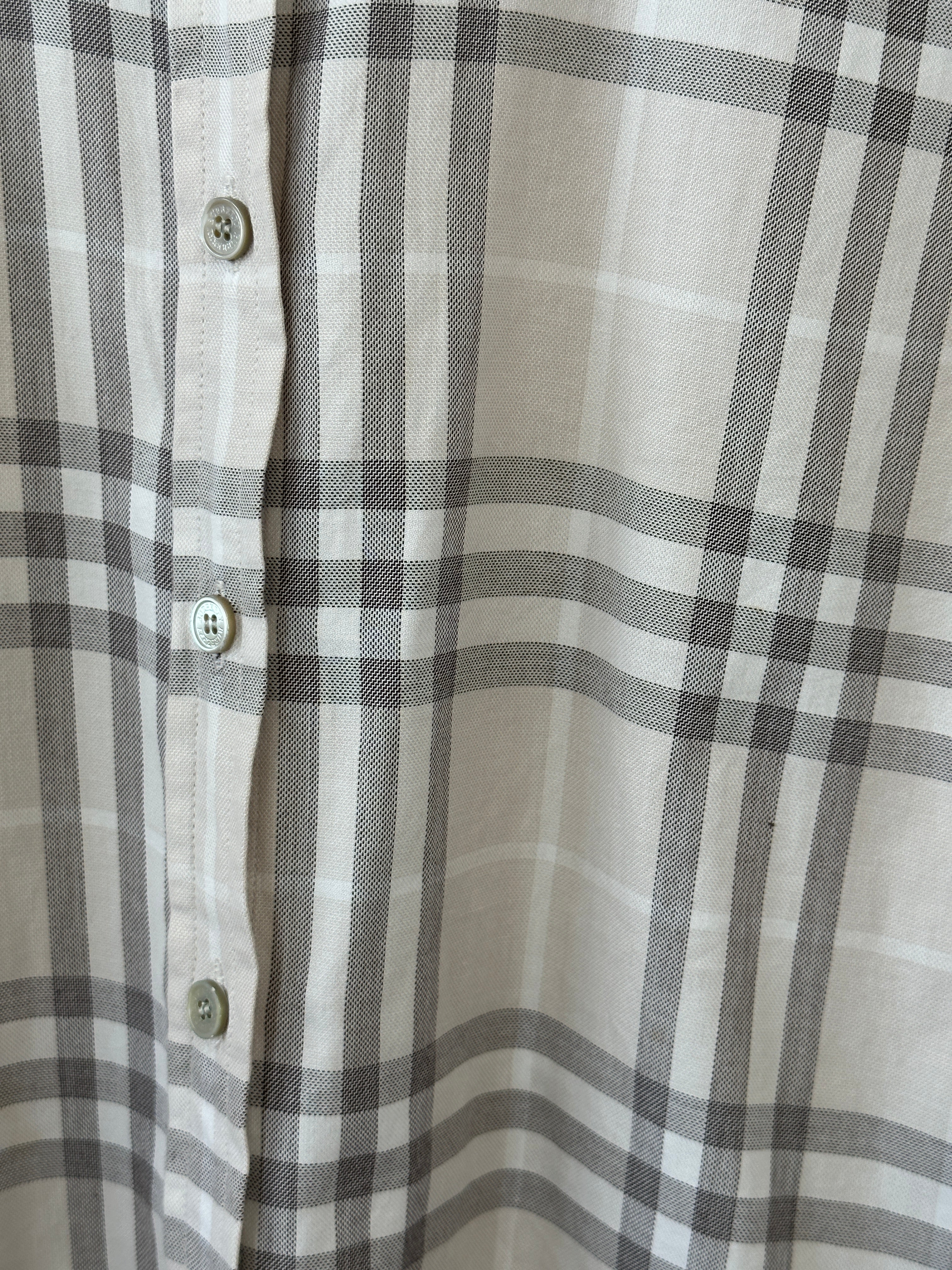 Burberry London Check cotton shirt in size L displayed on a hanger with the signature patterned fabric and classic collar.