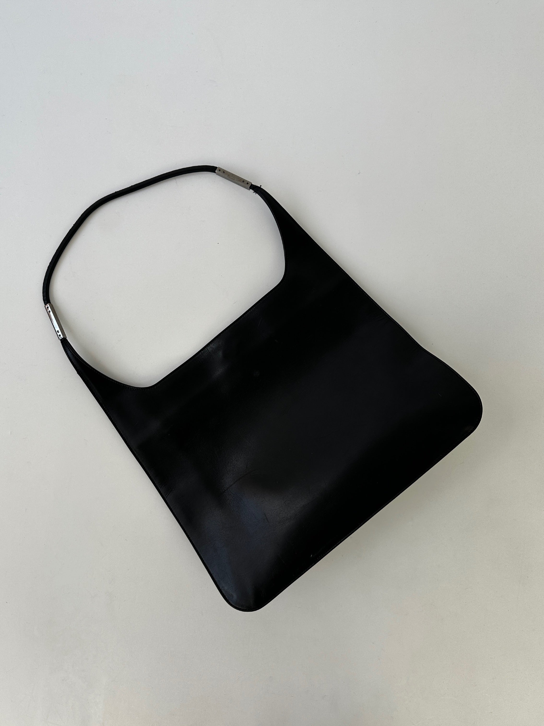 Gucci leather shoulder bag with adjustable strap, featuring a sleek design and signature Gucci logo on the front.