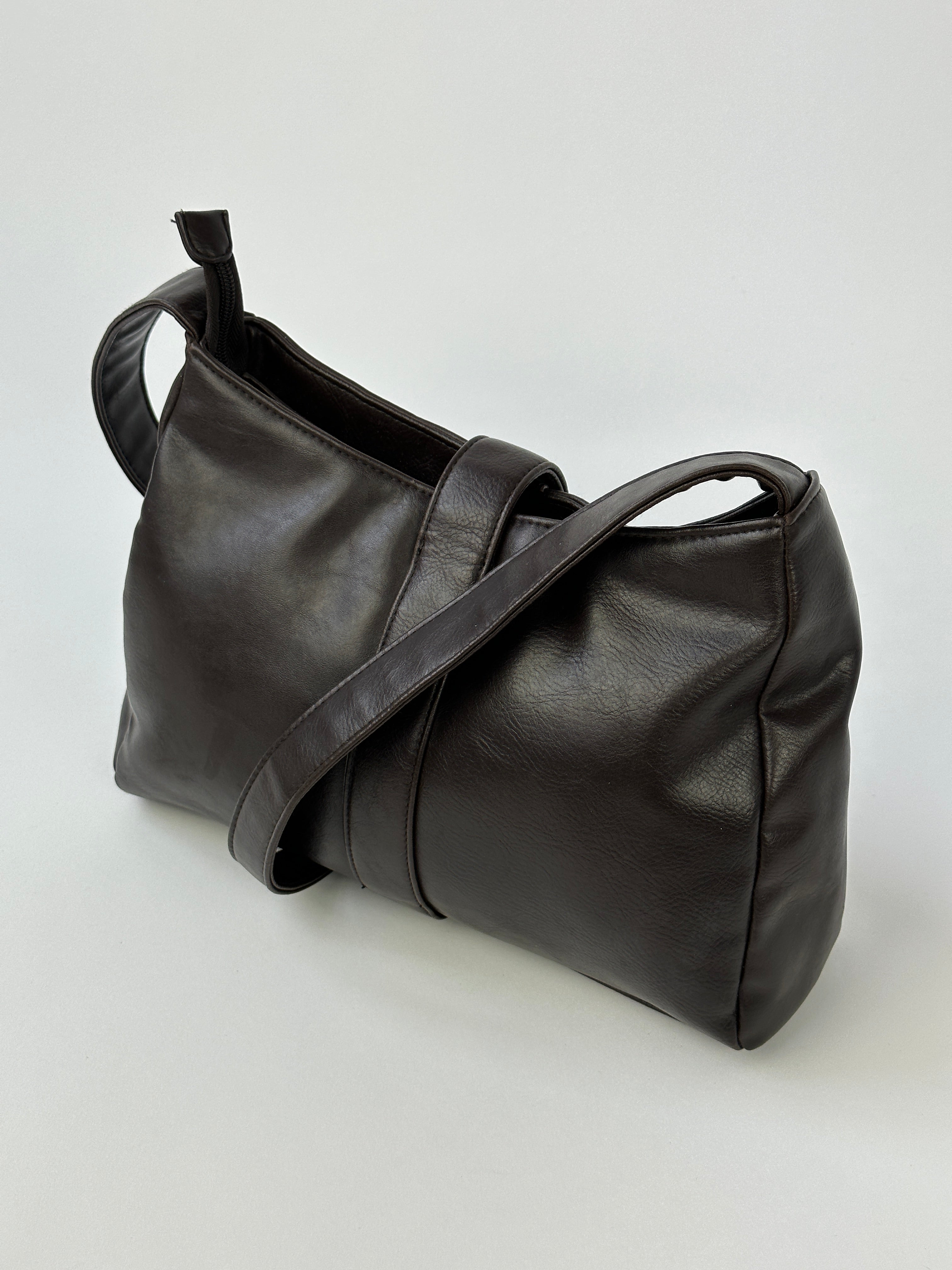 Vintage 2000s faux leather shoulder bag with adjustable strap and classic design, featuring a vintage-inspired look.