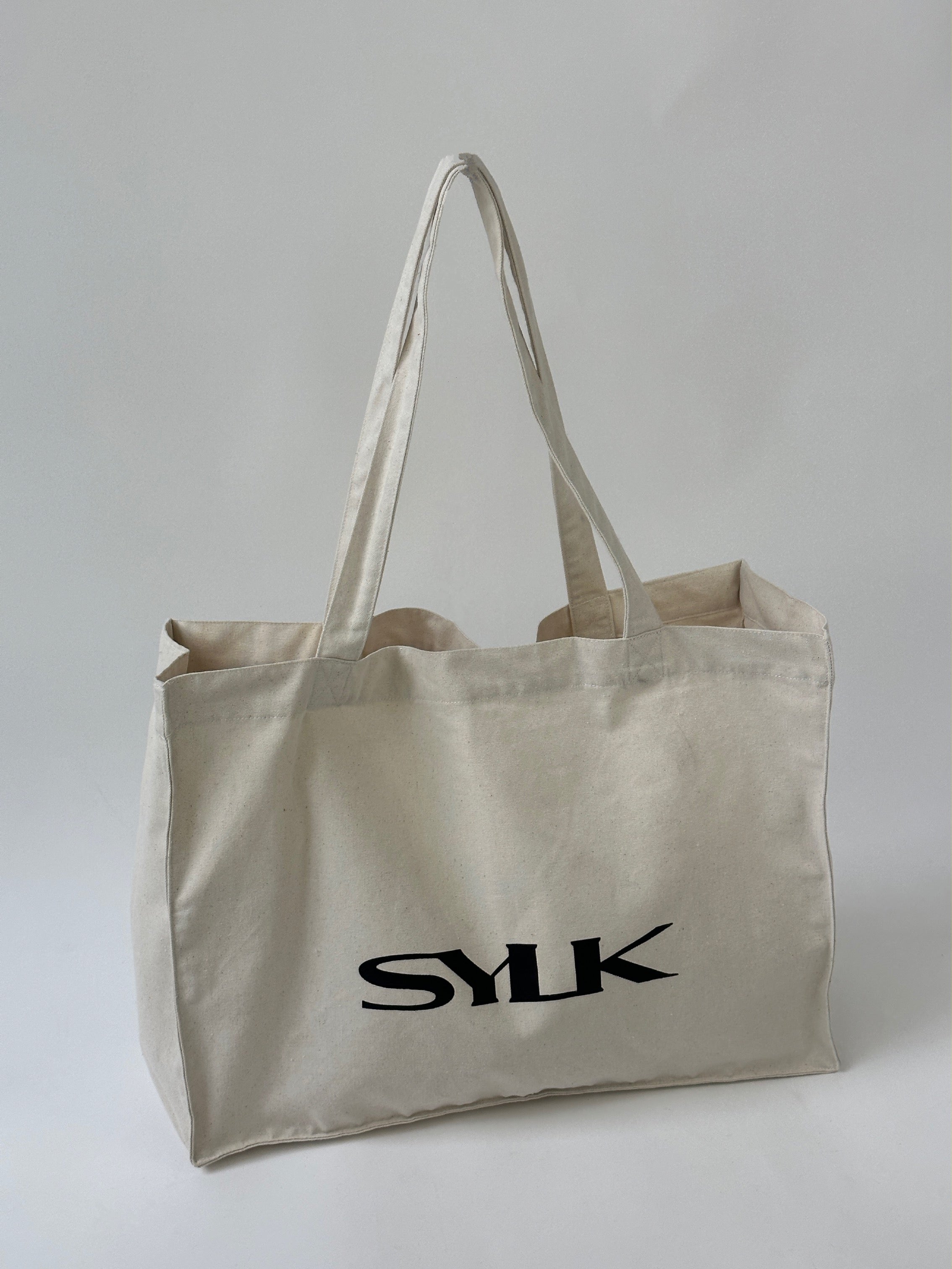 SYLK recycled cotton tote bag with sturdy handles, eco-friendly design, and natural woven texture for everyday use.