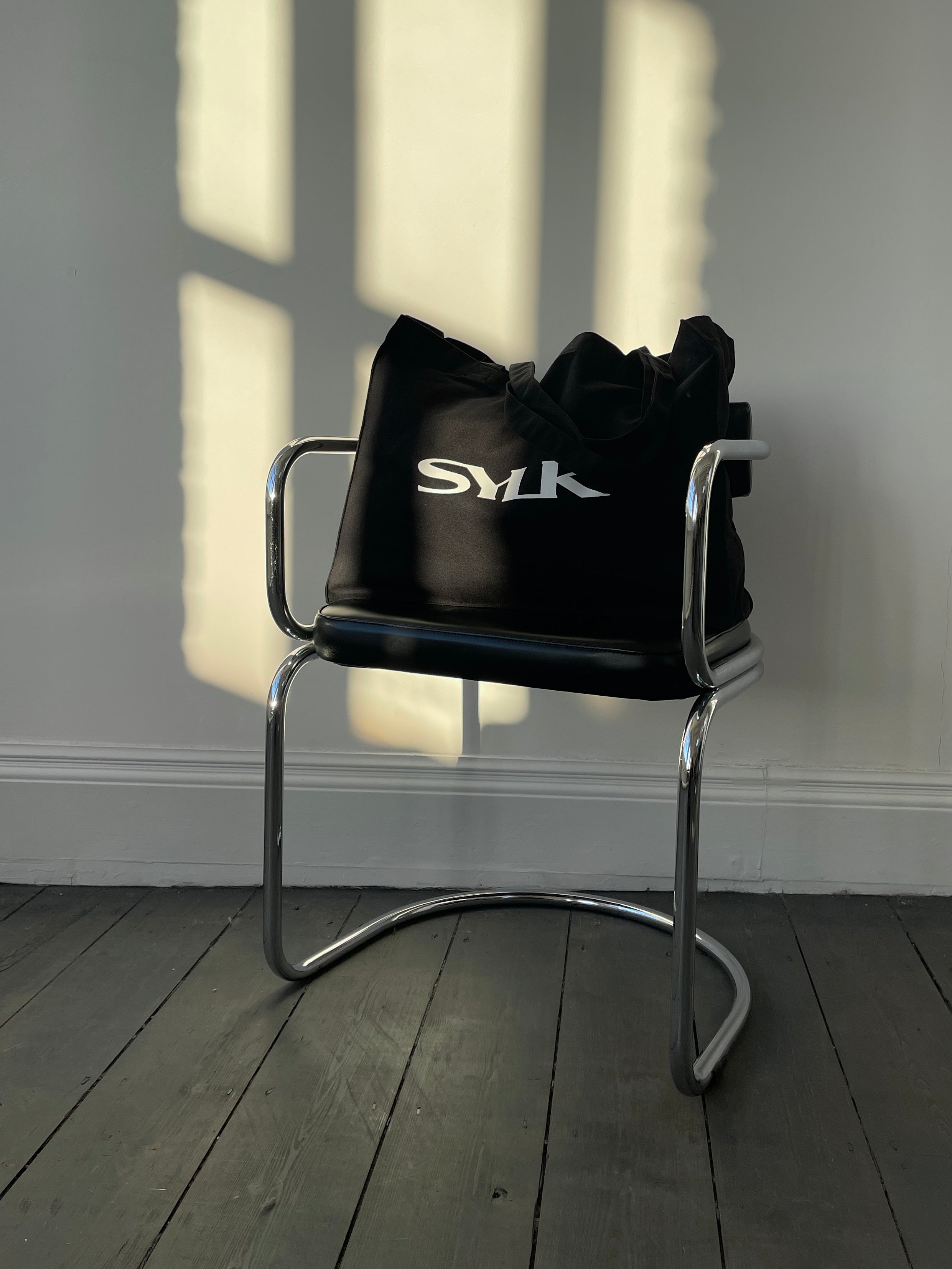 SYLK recycled cotton tote bag with eco-friendly design, featuring sturdy handles and natural fiber texture.