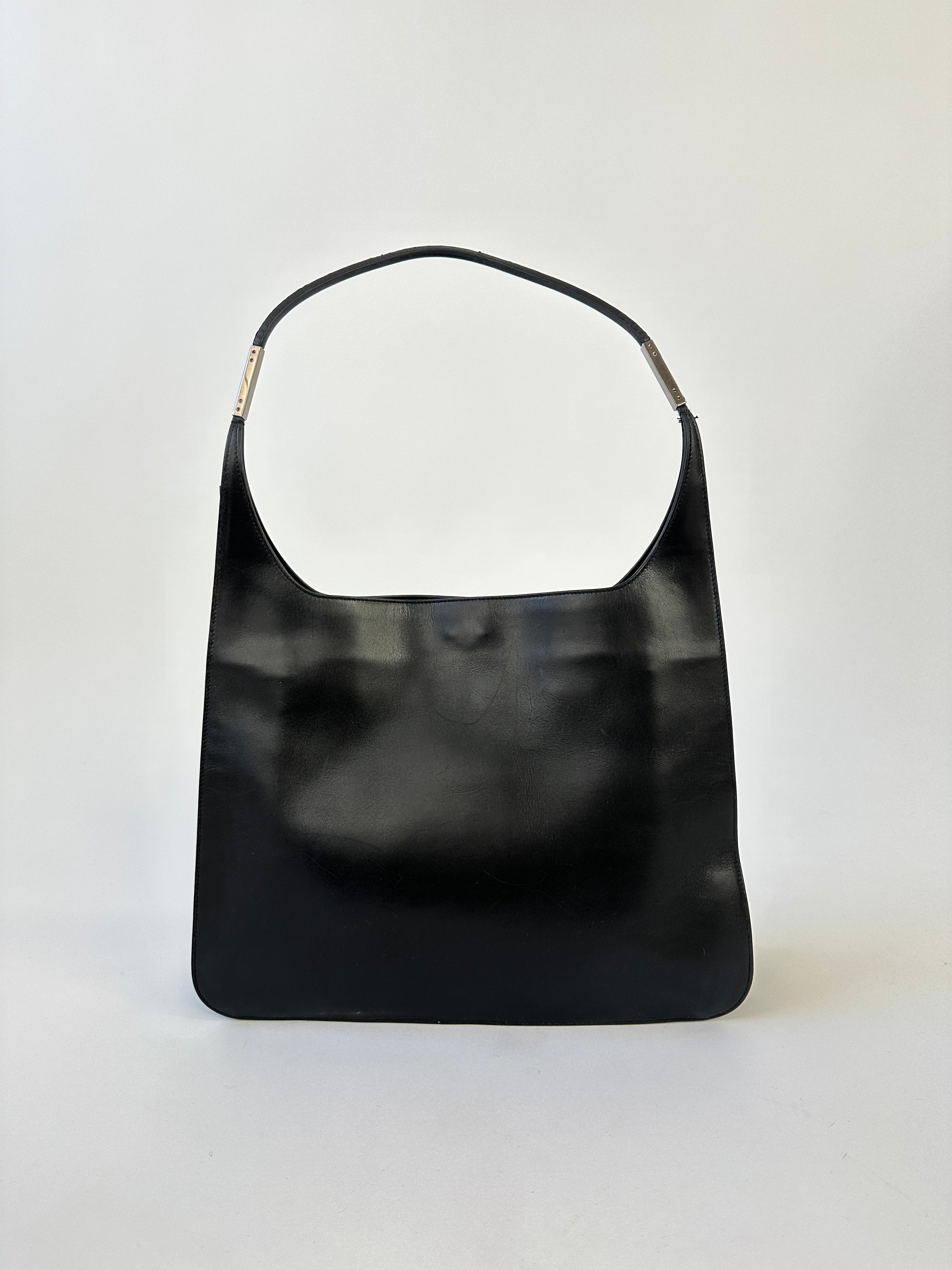 Gucci leather shoulder bag featuring a sleek design with a chain strap and iconic logo detail.
