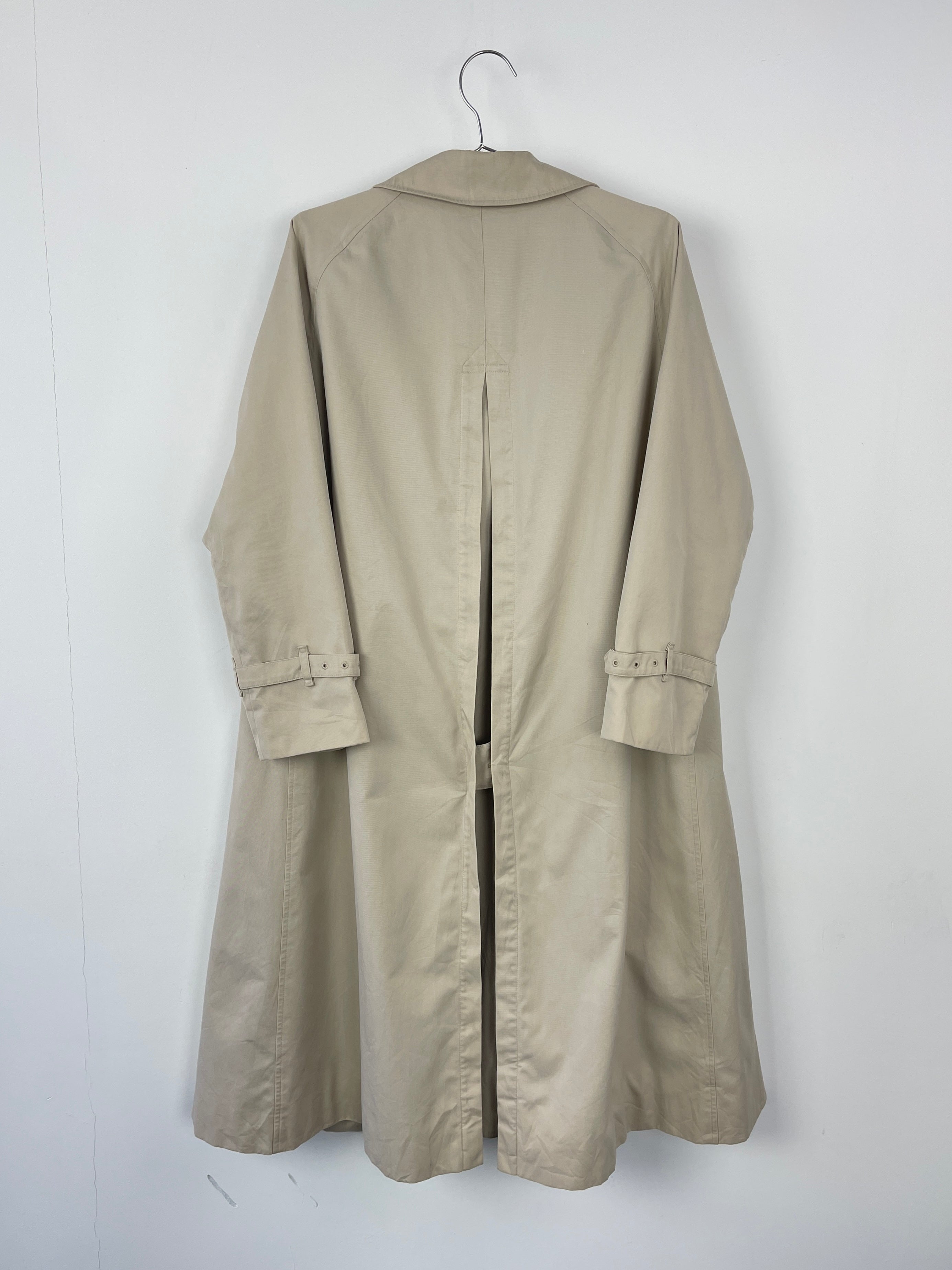 Beige Burberry trench coat displayed on a hanger, showcasing classic double-breasted design and signature check lining.