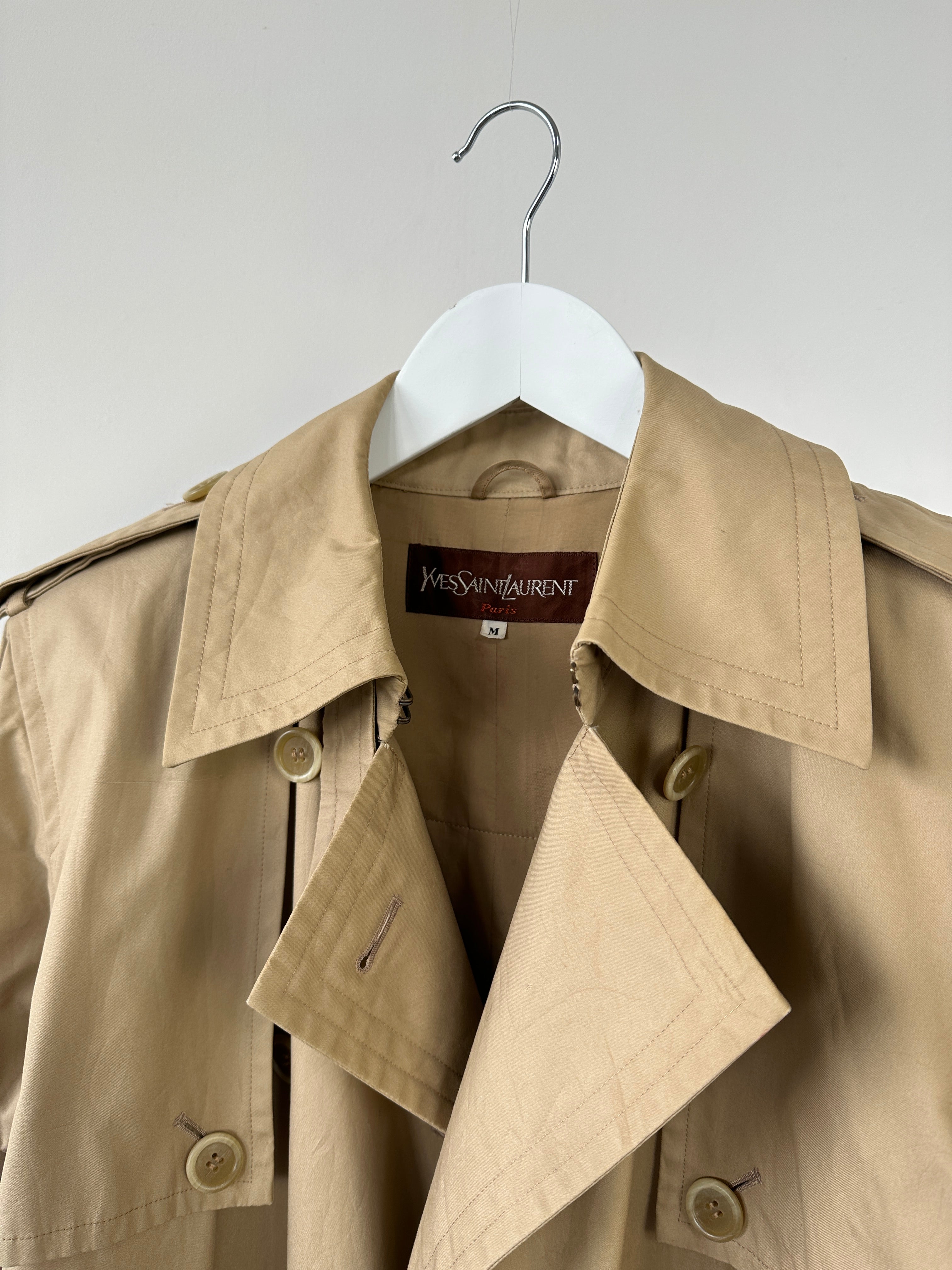 Yves Saint Laurent Paris double-breasted trench coat in size M, beige fabric with classic collar and button details.