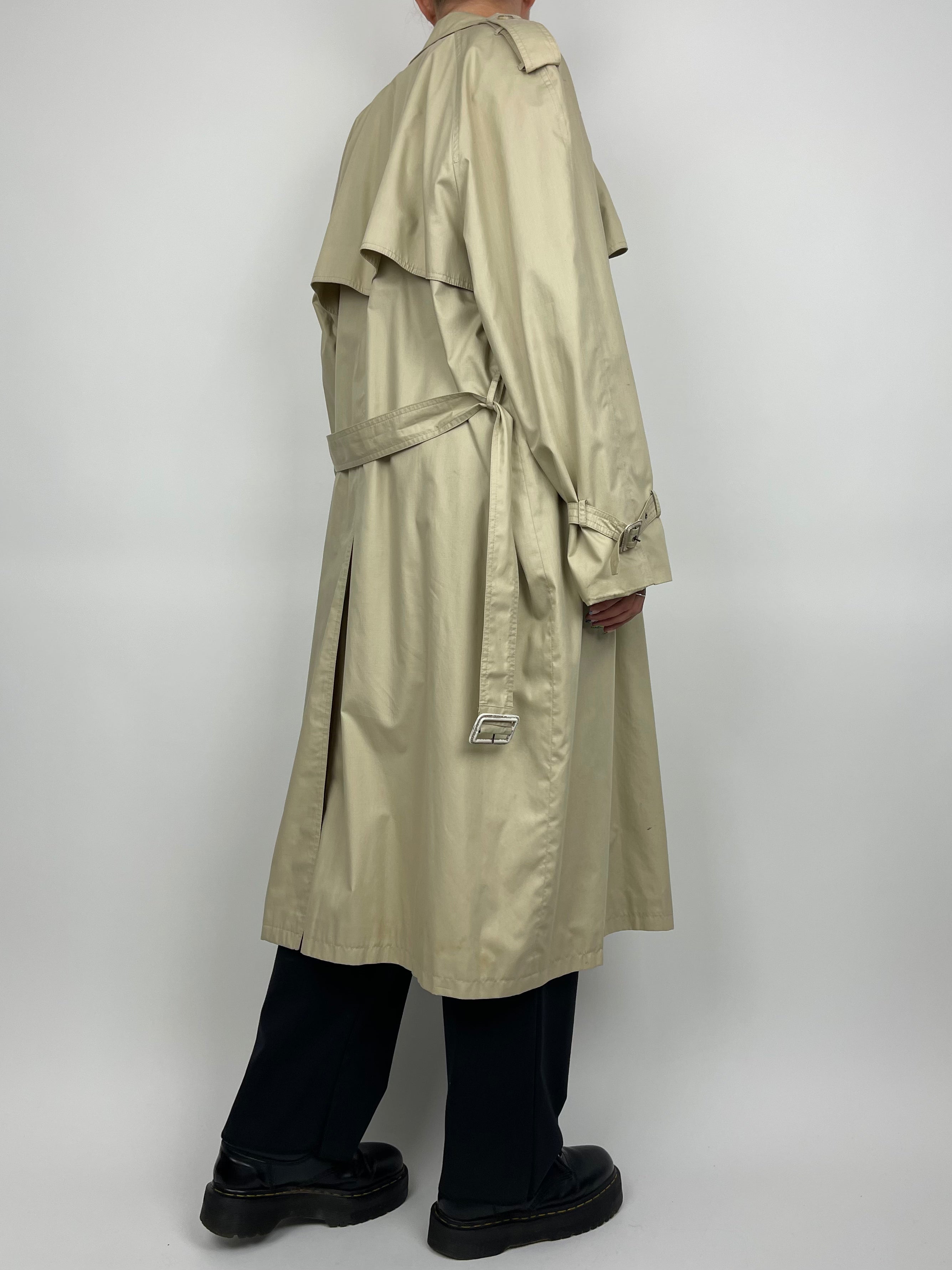 Yves Saint Laurent cotton trench coat hanging on a wooden hanger, showcasing classic beige color and tailored design.