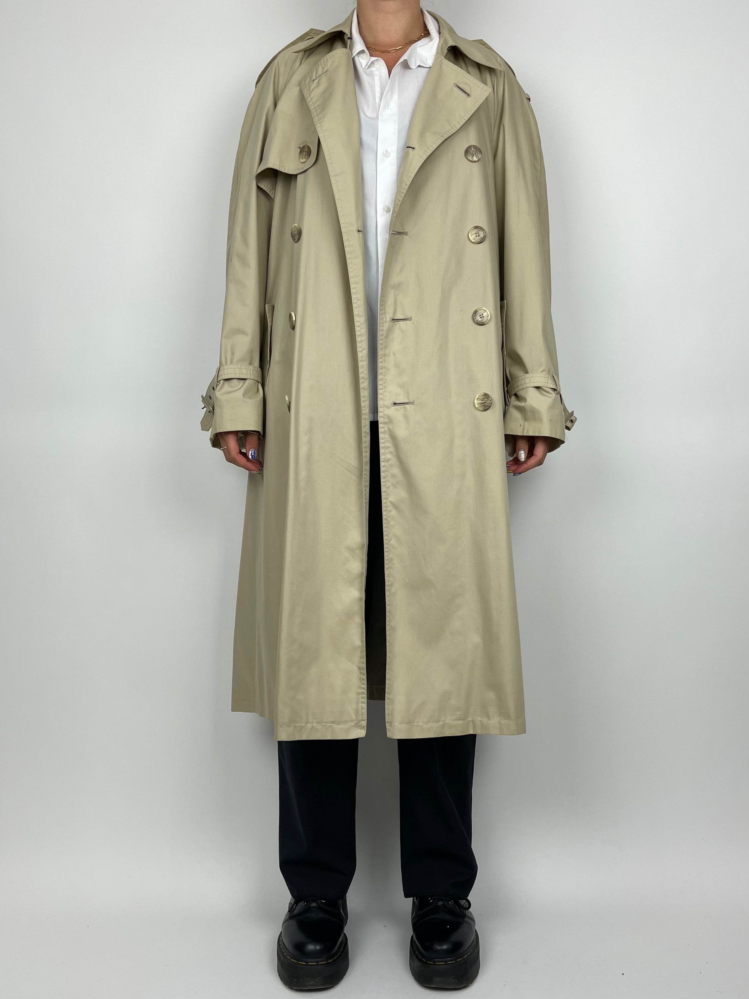 Yves Saint Laurent cotton trench coat displayed on a hanger, featuring classic design and neutral color.